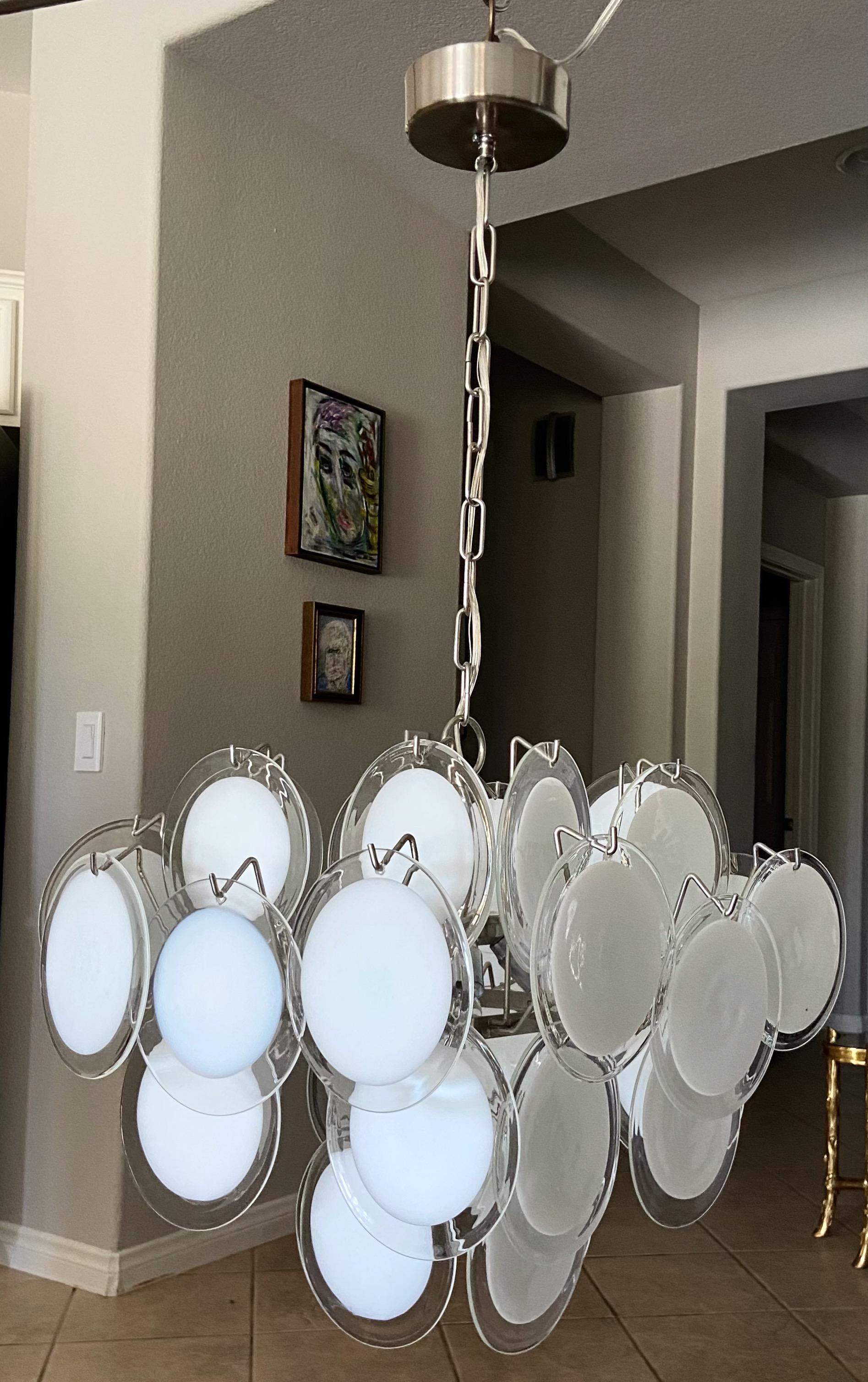 Clear and white disc Murano Italian glass 4 light chandelier. Steel frame. Uses 4 candelabra size bulbs, newly wired. The diagonal length is 24