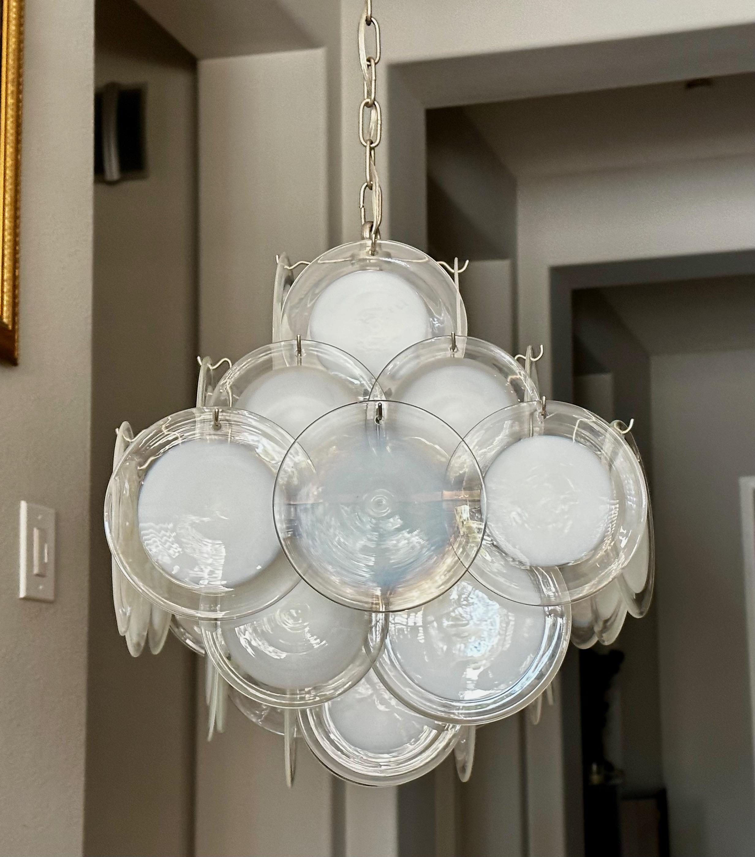 Lustre à 4 lumières en verre de Murano de Vistosi avec des disques ronds alternant clair et blanc plus blanc opalescent. Le cadre en acier est doté de 4 ampoules de taille candélabre. La longueur diagonale est de 23