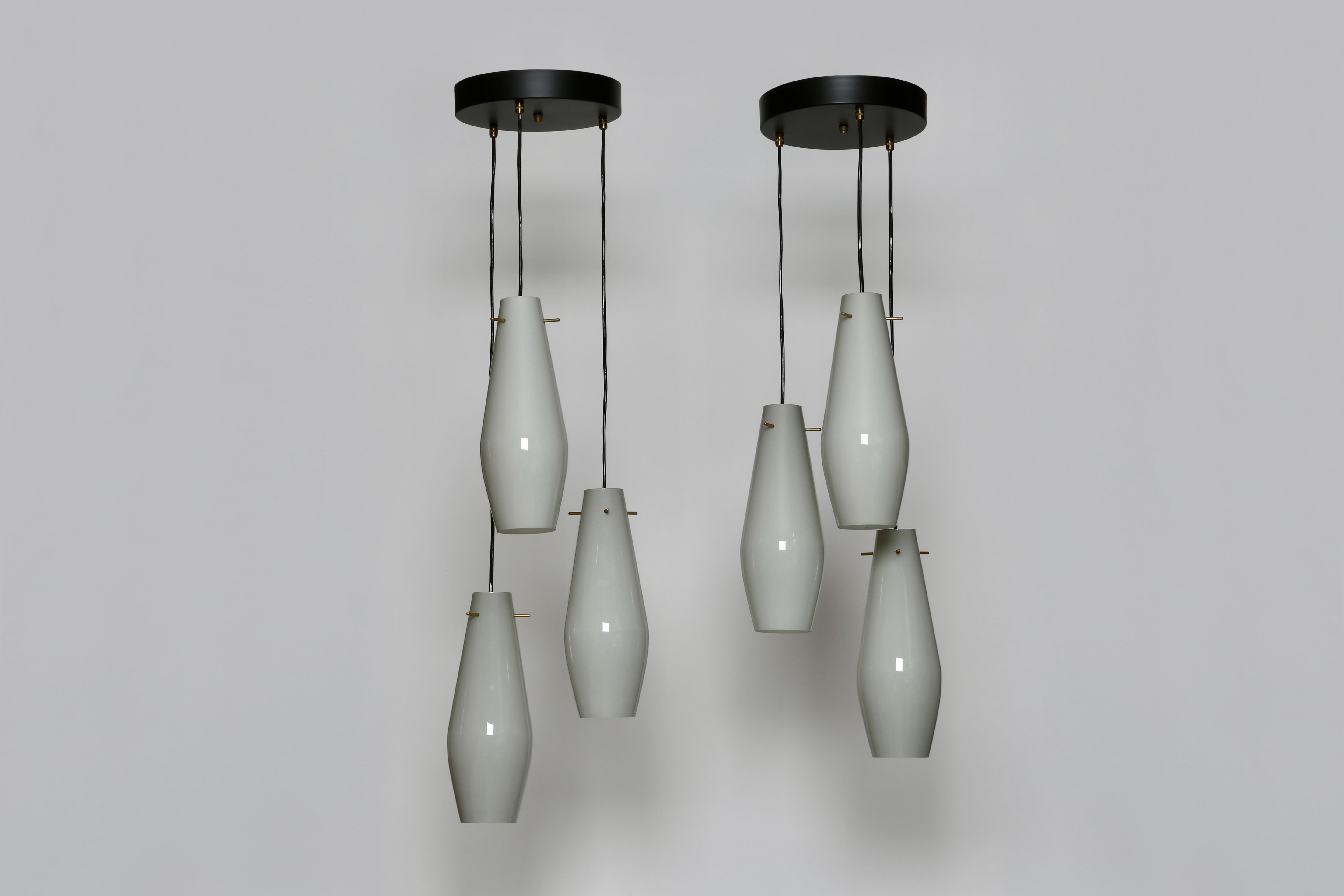 Murano glass ceiling suspensions by Vistosi.
Made in Italy 1960s
3 glass shades in double layered glass, gray on the outside, white inside.
Glass is 12 inches in height, 4.5 inches in diameter.
Overall drop is adjustable.
Each suspension takes 3