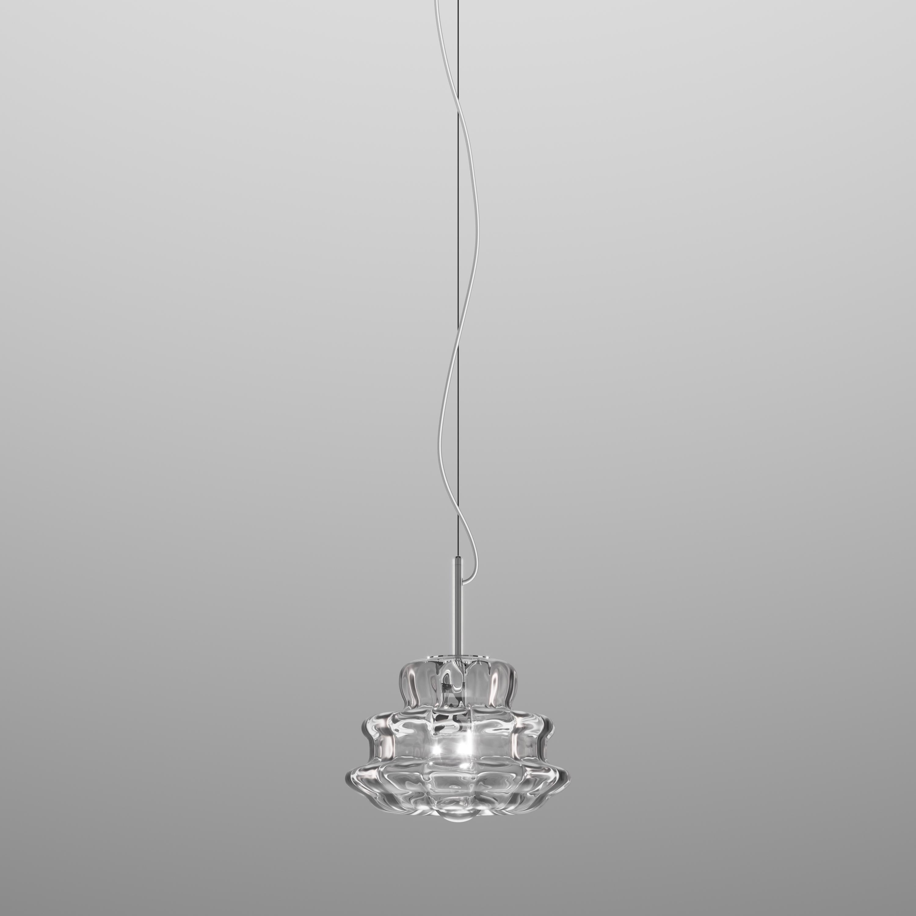 The shape of this collection stems from the desire to reinterpret the traditional Murano chandelier. The choice of the crystal or white rigadin glass finish was the master’s touch: its radial stripes evoke the arms of the historic candlestick while