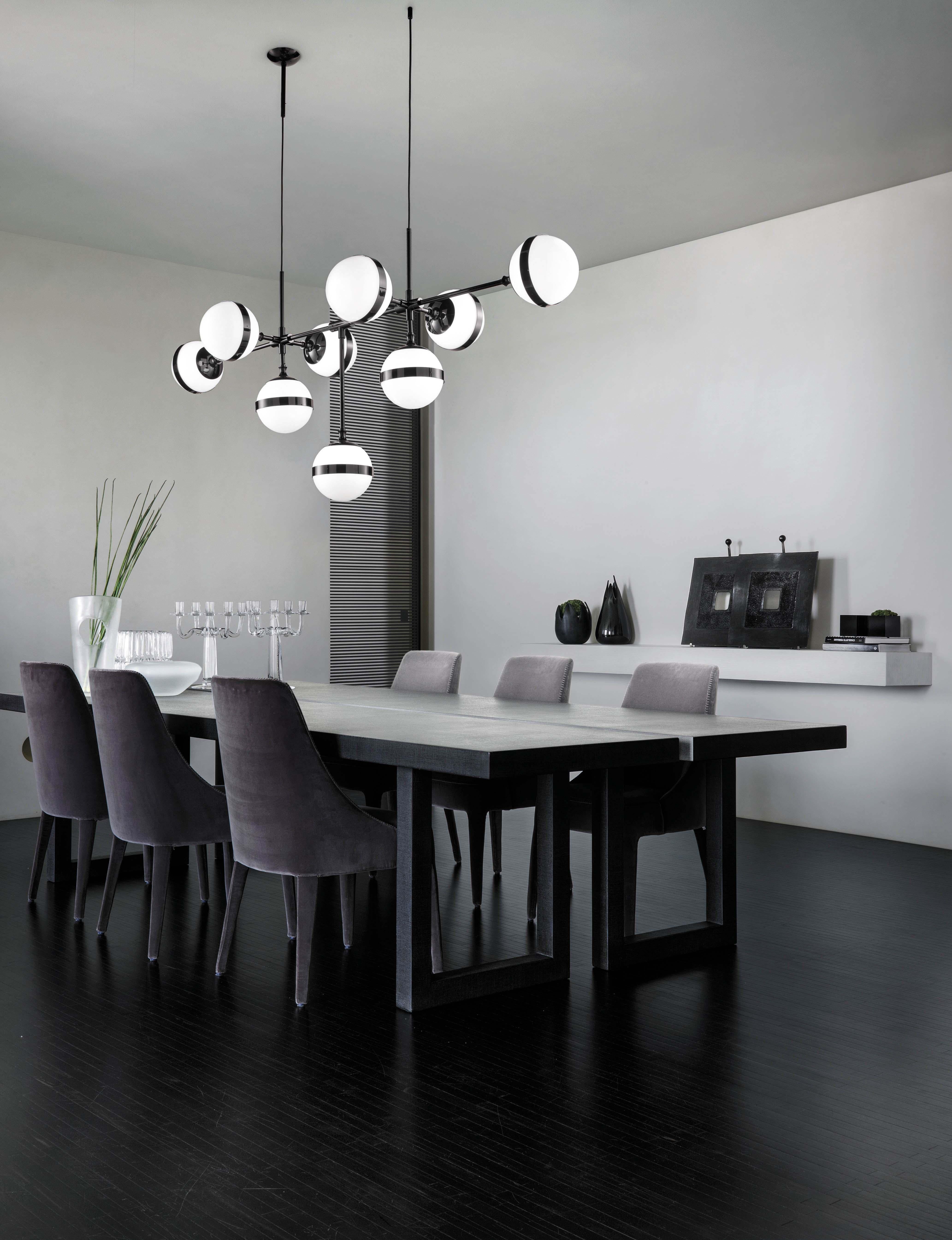 The white, blown handmade glass together with the glossy black metal, with a lead-effect treatment, interpret the polarity between black and white with the lightness of a rational and elegant design. With an impressive installation the lighting