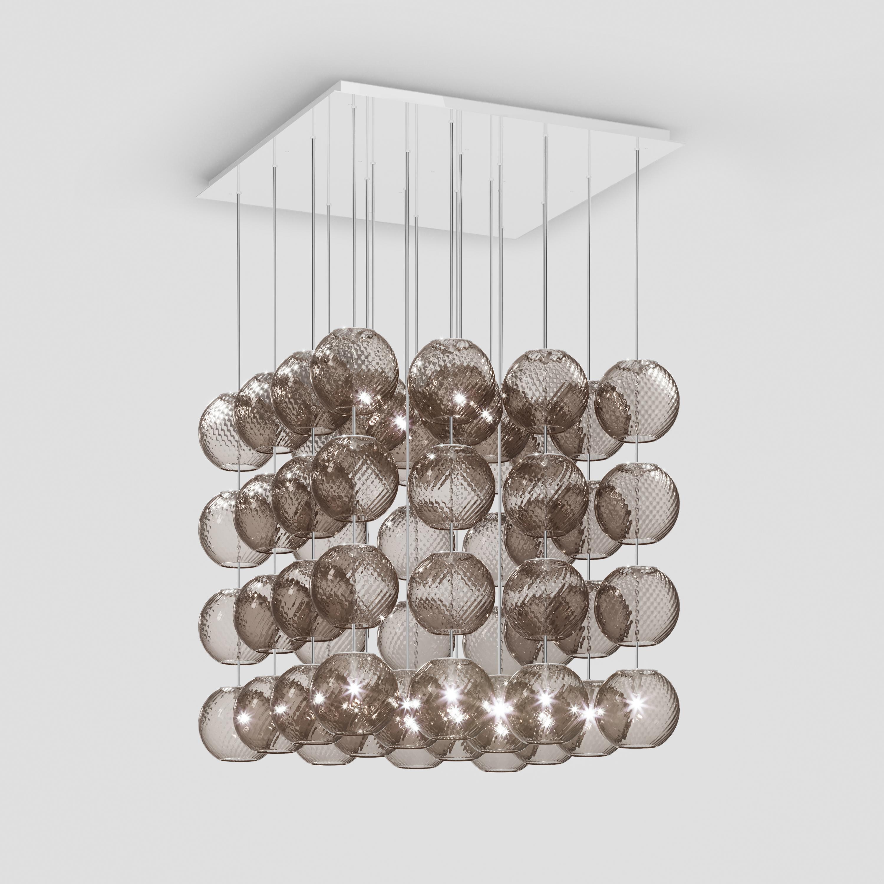Spherical blown glass elements available in three sizes and four rigadin colours, with and without lighting source. The special design allows the vertical installation of several glass elements and infinite customized