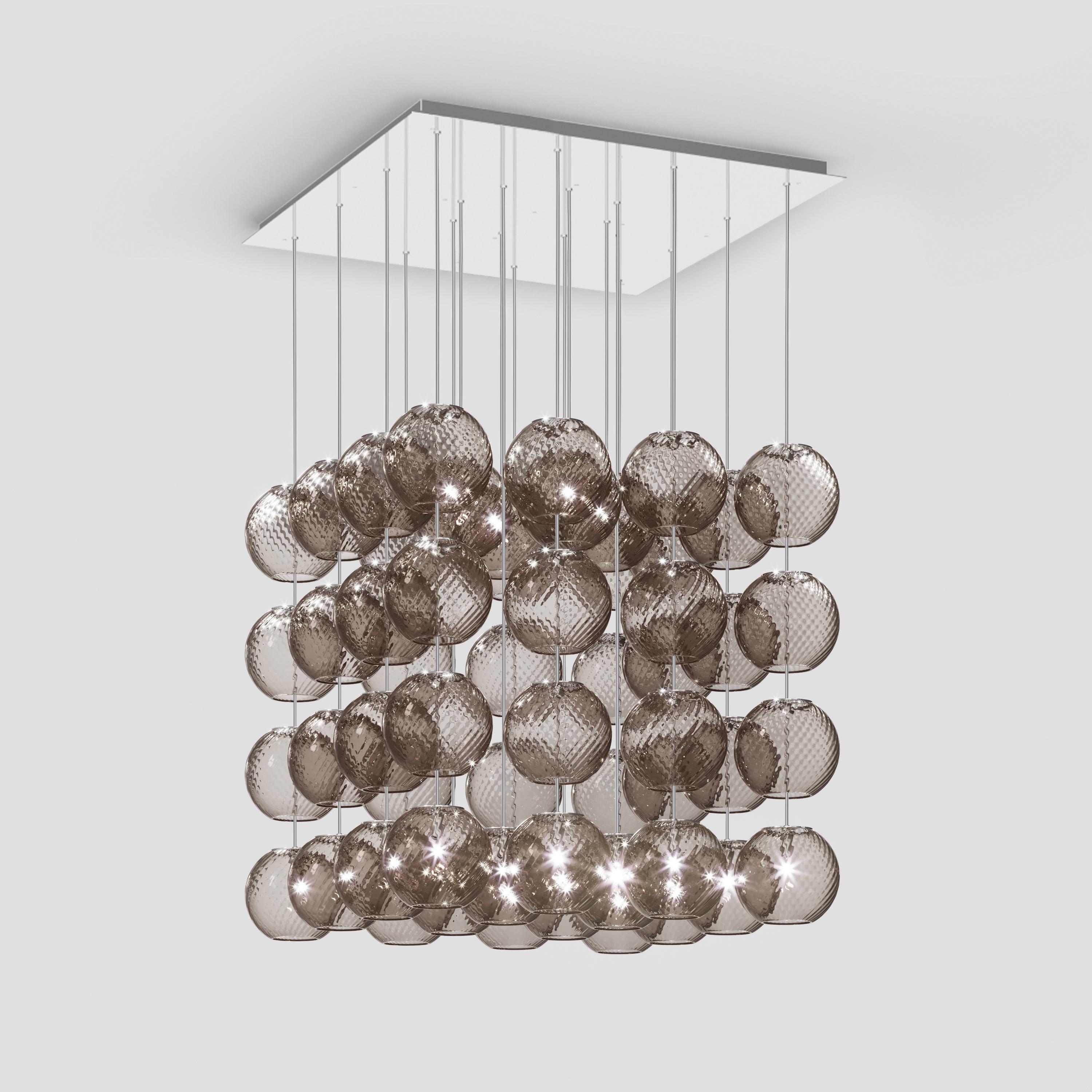 Spherical blown glass elements available in three sizes and four rigadin colours, with and without lighting source. The special design allows the vertical installation of several glass elements and infinite customized