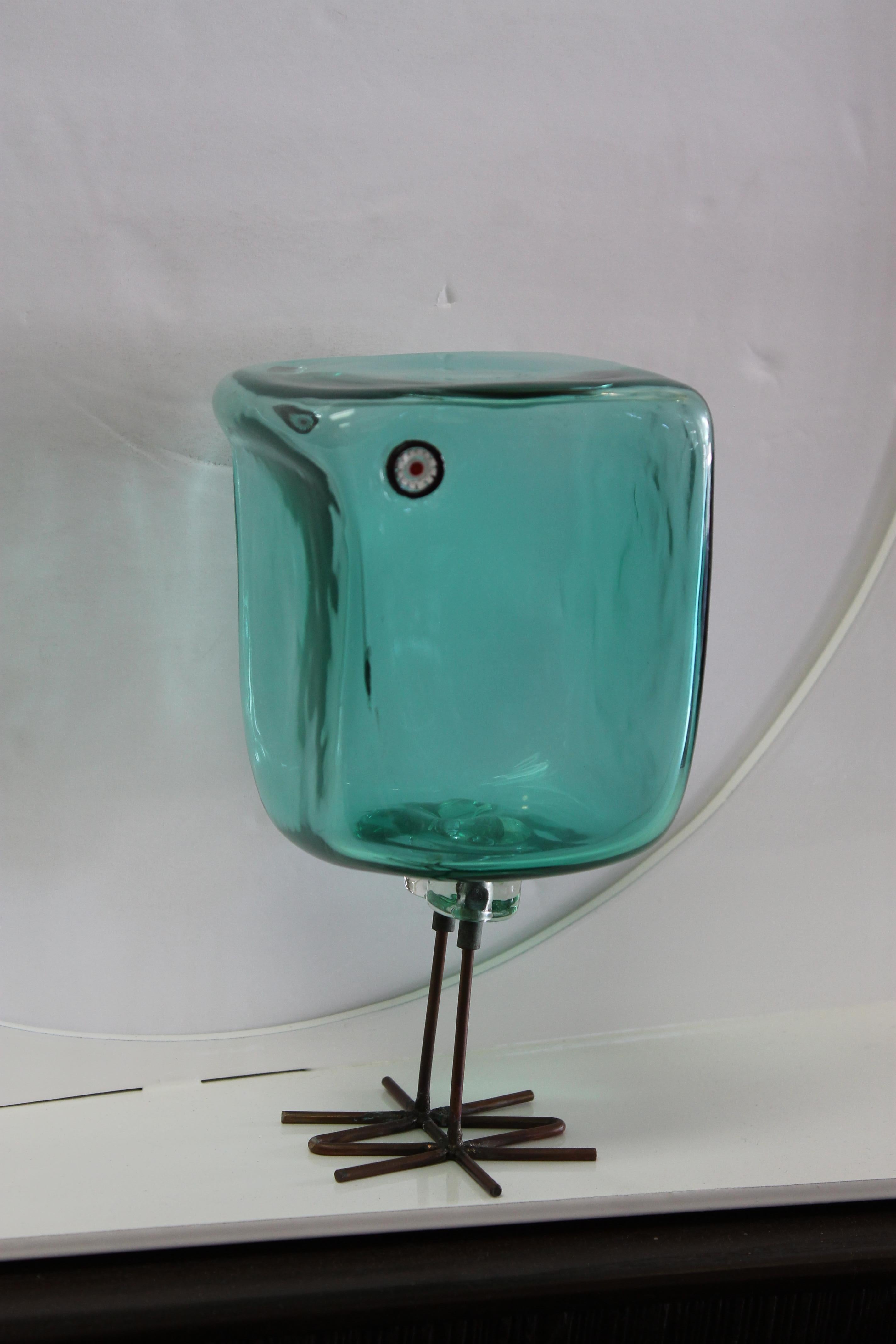 Blown glass cube bird by Pianon for Vistosi, circa 1963-1964. Blue-green color with millefiori eyes (black, white and red), copper legs. There are two fractures along two edges. We've been advised that these occurred during manufacture but we cannot