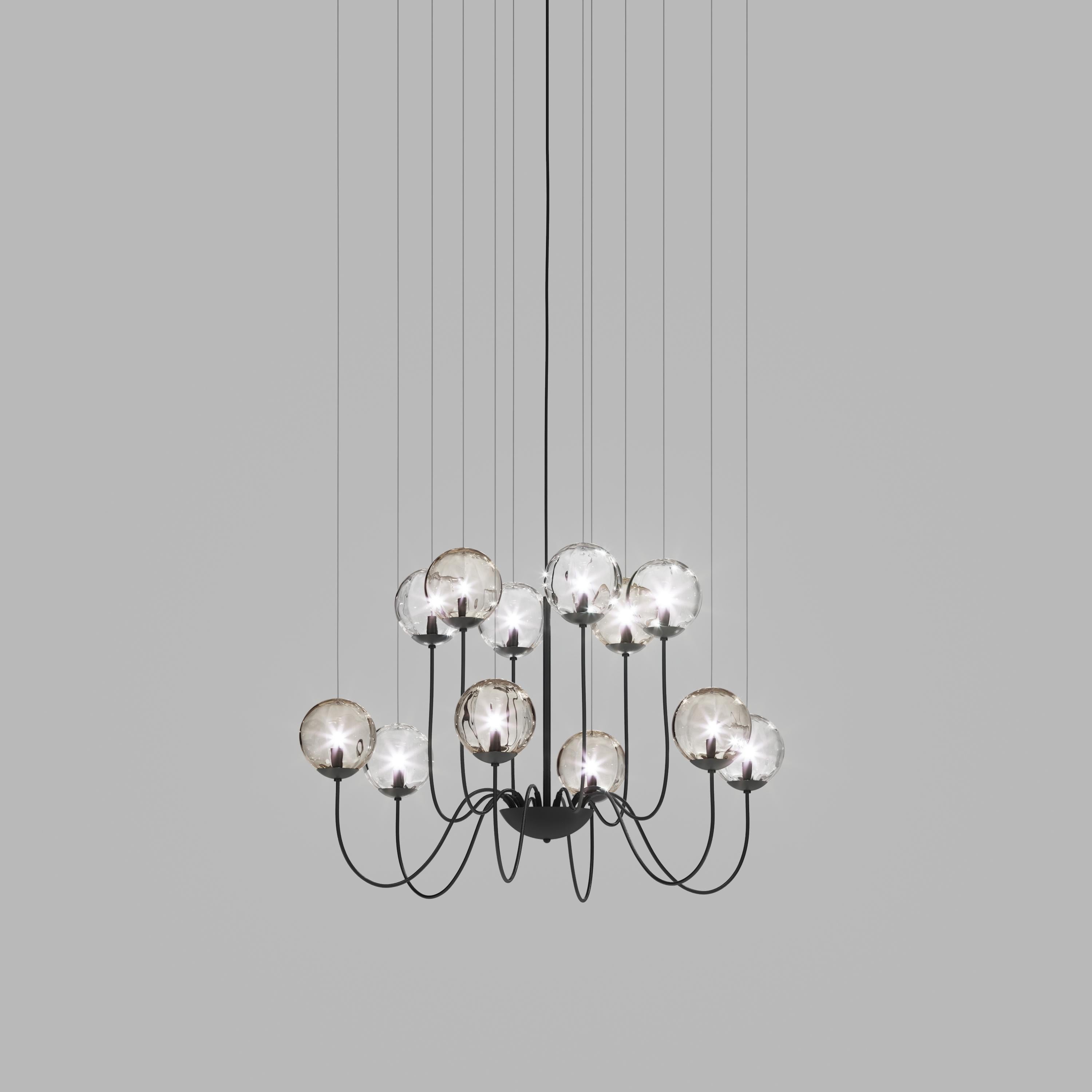 Collection of lamps with a blown and irregular striped glass diffuser. The three sizes of the spheres and the different cable heights are designed to create elegant compositions. The chandelier version allows to fix the diffusers with steel cables