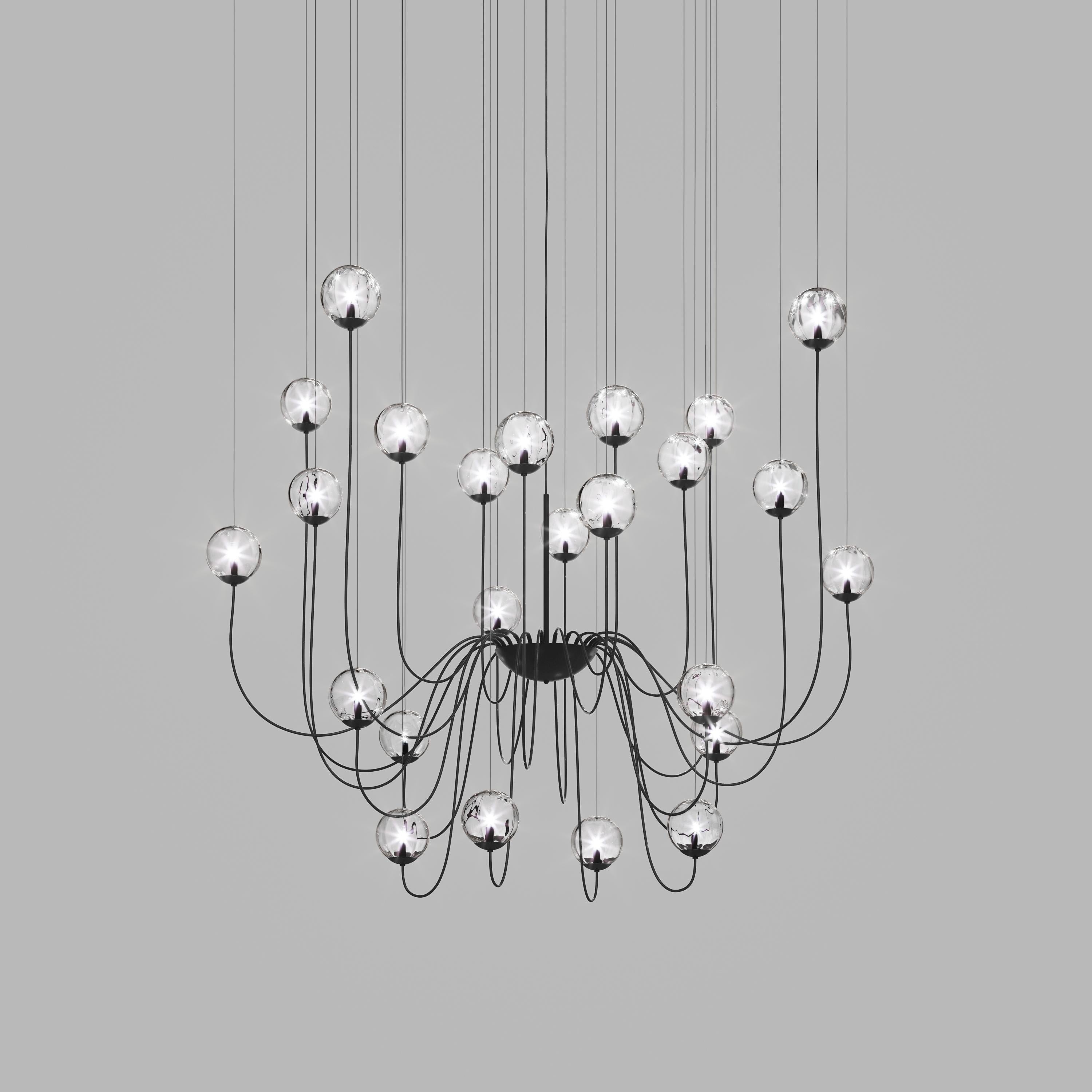 Collection of lamps with a blown and irregular striped glass diffuser. The three sizes of the spheres and the different cable heights are designed to create elegant compositions. The chandelier version allows to fix the diffusers with steel cables