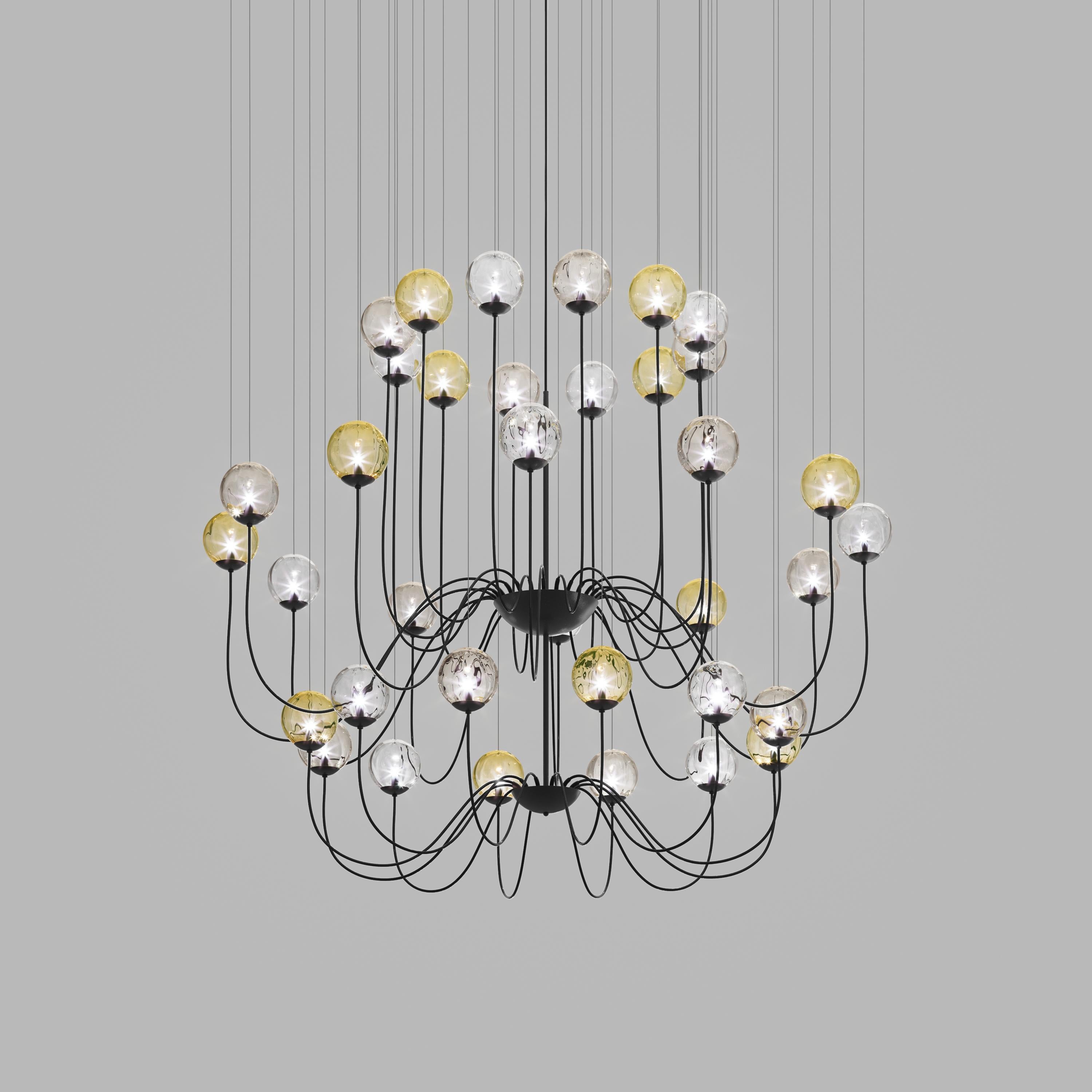 Collection of lamps with a blown and irregular striped glass diffuser. The three sizes of the spheres and the different cable heights are designed to create elegant compositions. The chandelier version allows to fix the diffusers with steel cables
