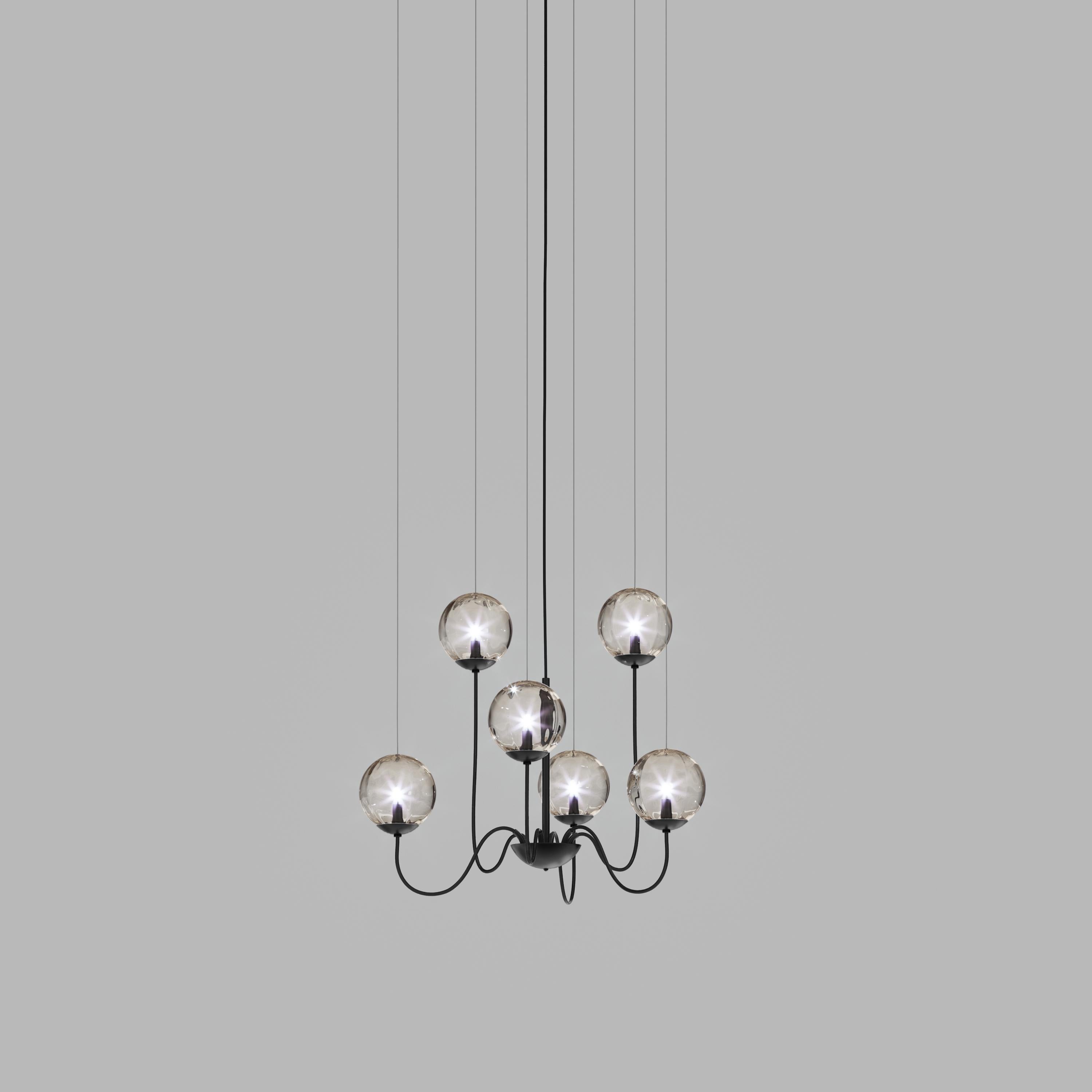 Collection of lamps with a blown and irregular striped glass diffuser. The three sizes of the spheres and the different cable heights are designed to create elegant compositions. The chandelier version allows to fix the diffusers with steel cables