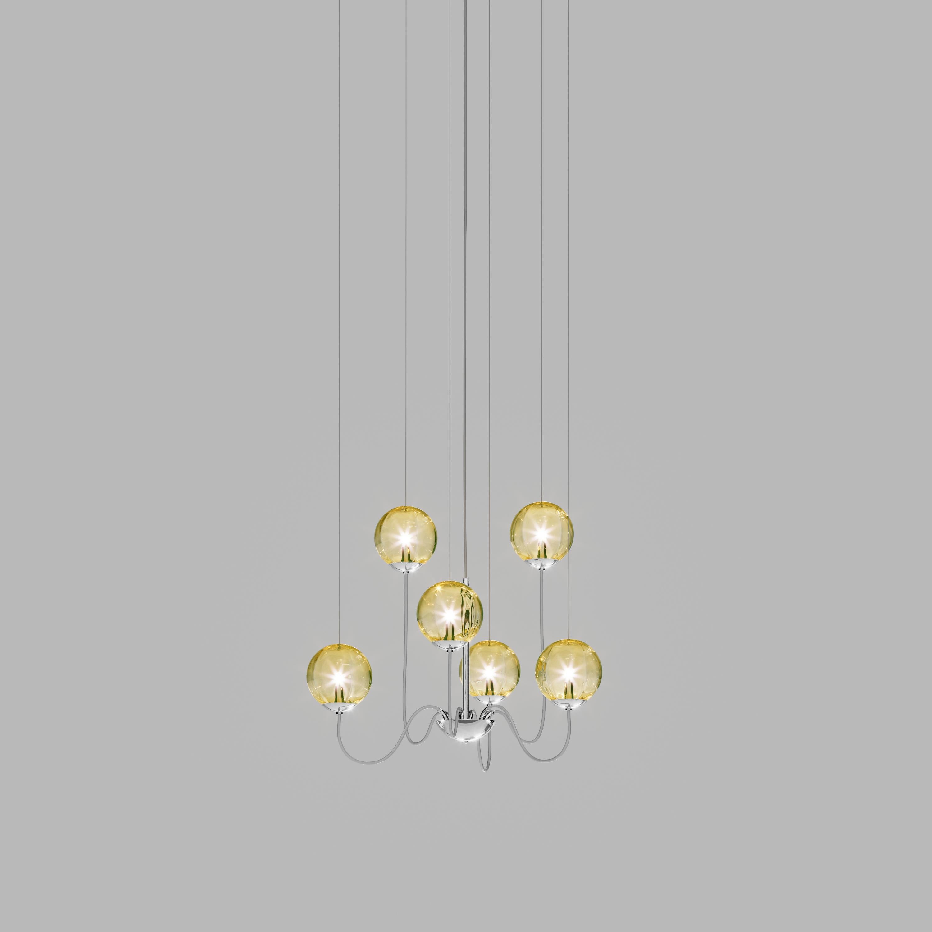 Collezione di lampade con diffusore in vetro soffiato e irregolare a righe. Le tre dimensioni delle sfere e le diverse altezze dei cavi sono pensate per creare composizioni eleganti. La versione lampadario permette di fissare i diffusori con cavi