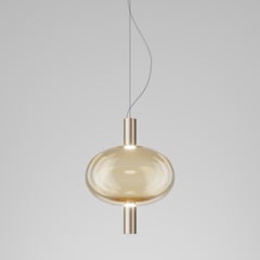 Vistosi Riflesso è una lampada a sospensione in vetro ambrato transaprent e montatura in oro opaco