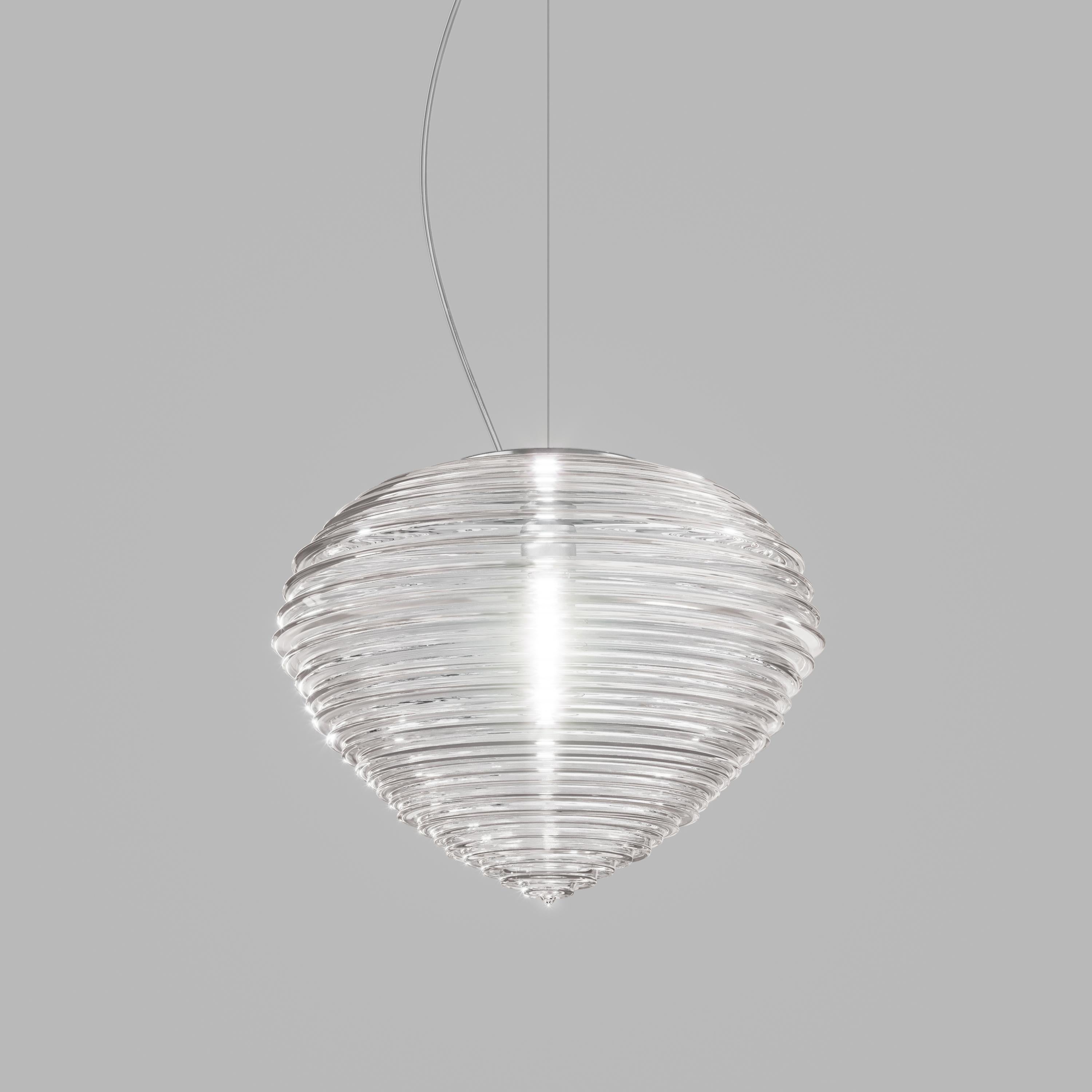 Sprit has the shape of a diamond blown into glass. Its folds are the result of a long process of development that creates a unique light reflection,  while keeping the source of light hidden even in the transparent crystal