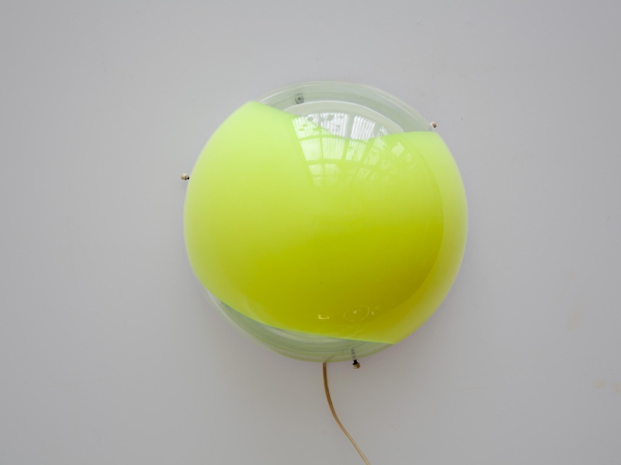Rare wall light or sconce consisting of a half sphere of clear glass with a warm yellow opal swirl blown inside, designed in Murano by vistosi 1960s, mounted on a metal white lacquered wall plate.