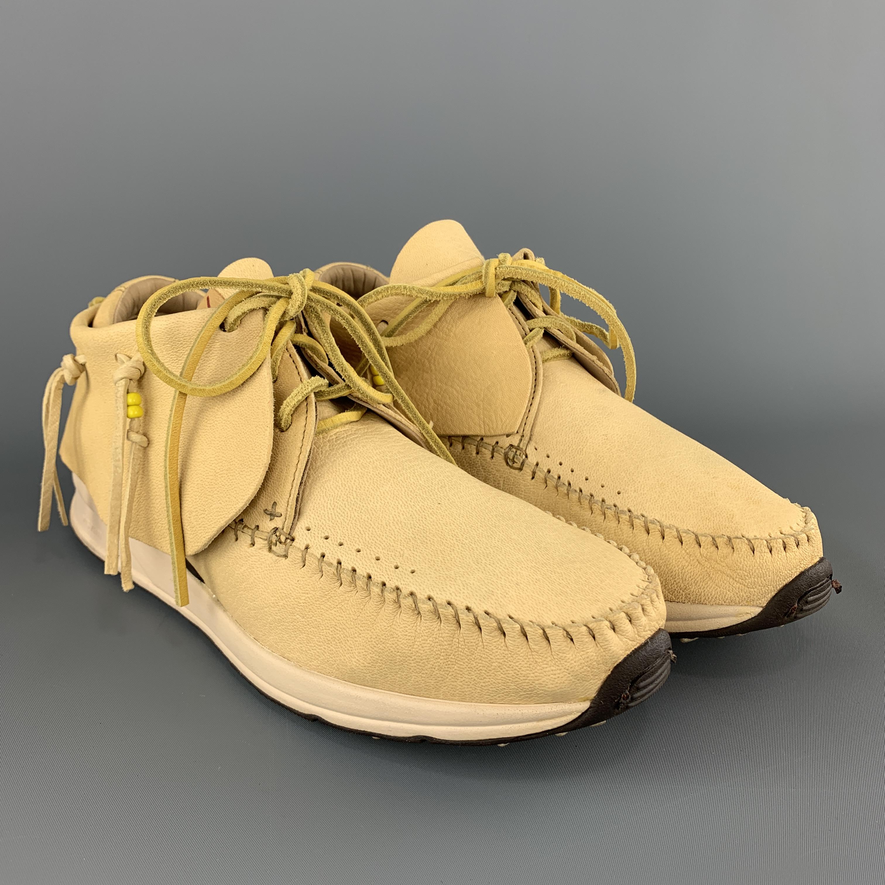 VISVIM FBT RED DEER mid sneakers come in light yellow leather with an apron toe, cream rubber sole, and flap with leather tied fringes. Hand made. With box. 

Very Good Pre-Owned Condition.
Marked: US 11

Outsole: 11.75 x 4 in.