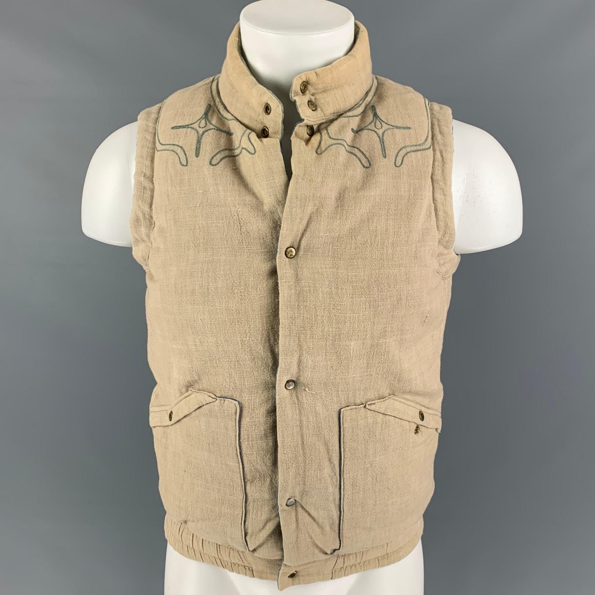 VISVIM vest comes in a multi-color padded cotton / linen featuring a reversible style, embroidered design, front pockets, elastic trim, and a snap button closure. Made in Japan.Very Good
Pre-Owned Condition. Minor discoloration. As-is.  

Marked:  