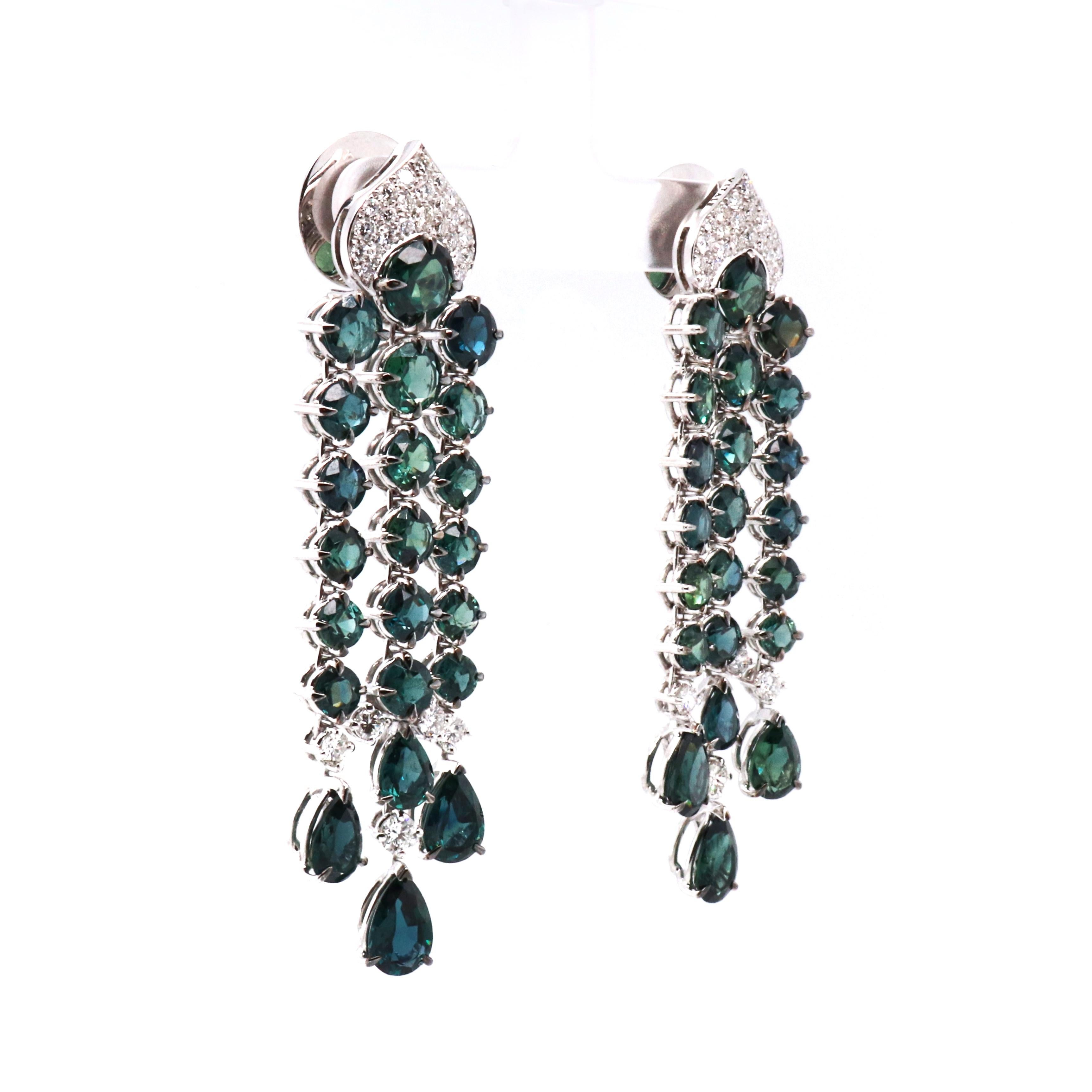 These 18K white gold chandelier earrings are from Divine collection. These chandelier earrings are created with natural white diamonds 1.41 Carat and round and pear shape natural greenish blue sapphires in total of 24.44 Carat. They are 6.5 cm long.