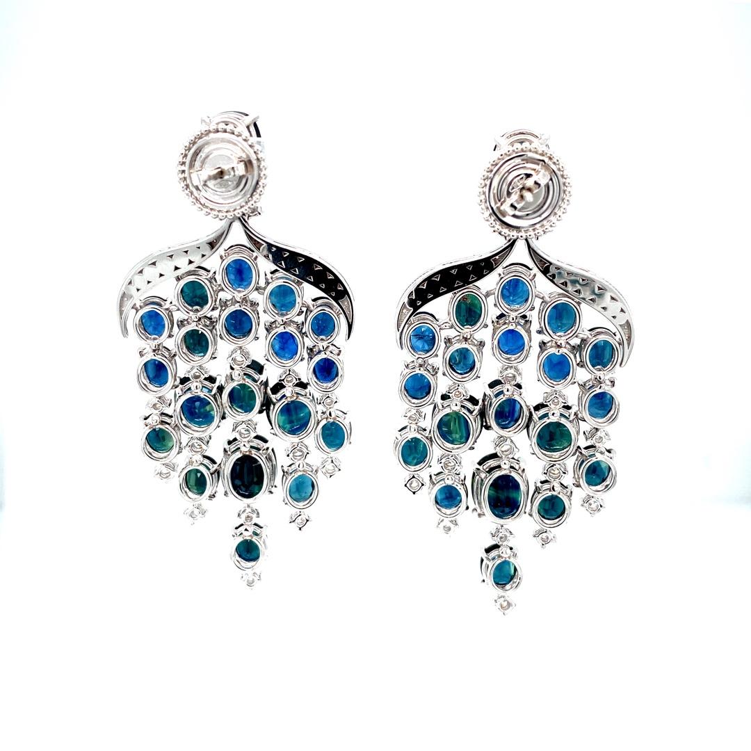 These 18K white gold trendy chandelier earrings are from our Divine collection. These chandelier earrings is a perfect blend of natural white diamonds 2.6 Carat and natural oval shape blue sapphires 43.85 Carat. This piece of jewellery is an ideal