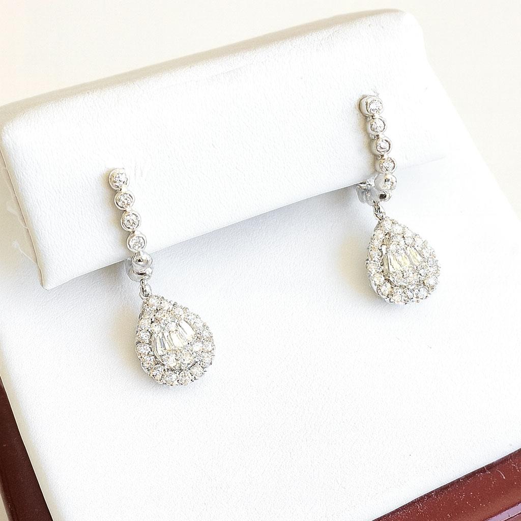 Eleganti e senza tempo, questi squisiti orecchini di diamanti a goccia sono finemente realizzati in oro bianco 18 carati e pesano 4,4 grammi. Ogni orecchino presenta un'abbagliante serie di diamanti rotondi e a taglio baguette per un totale di circa