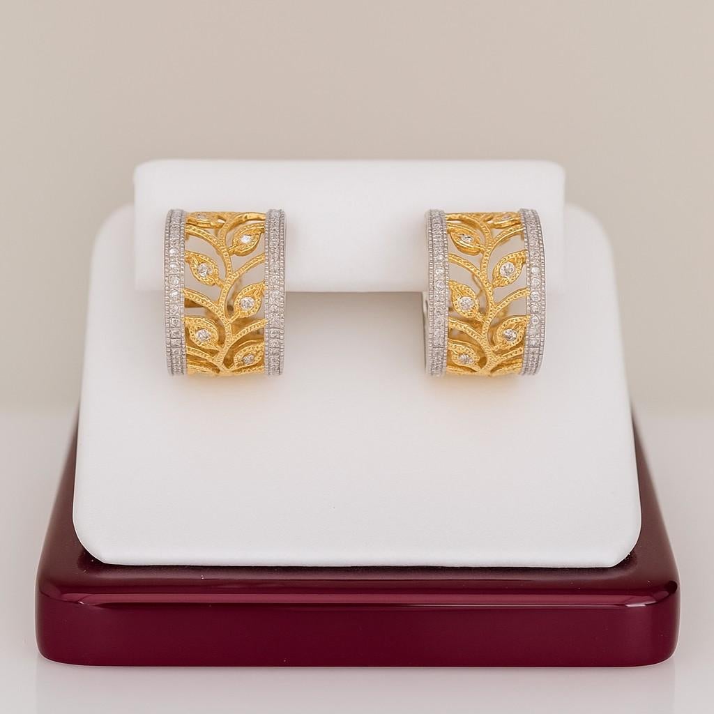 A stunning pair of handcrafted 18K white and yellow gold earrings featuring an intricate openwork leaf motif. Set with approximately 0.84 carats of brilliant round diamonds, these earrings radiate timeless Italian elegance. The design is enhanced by