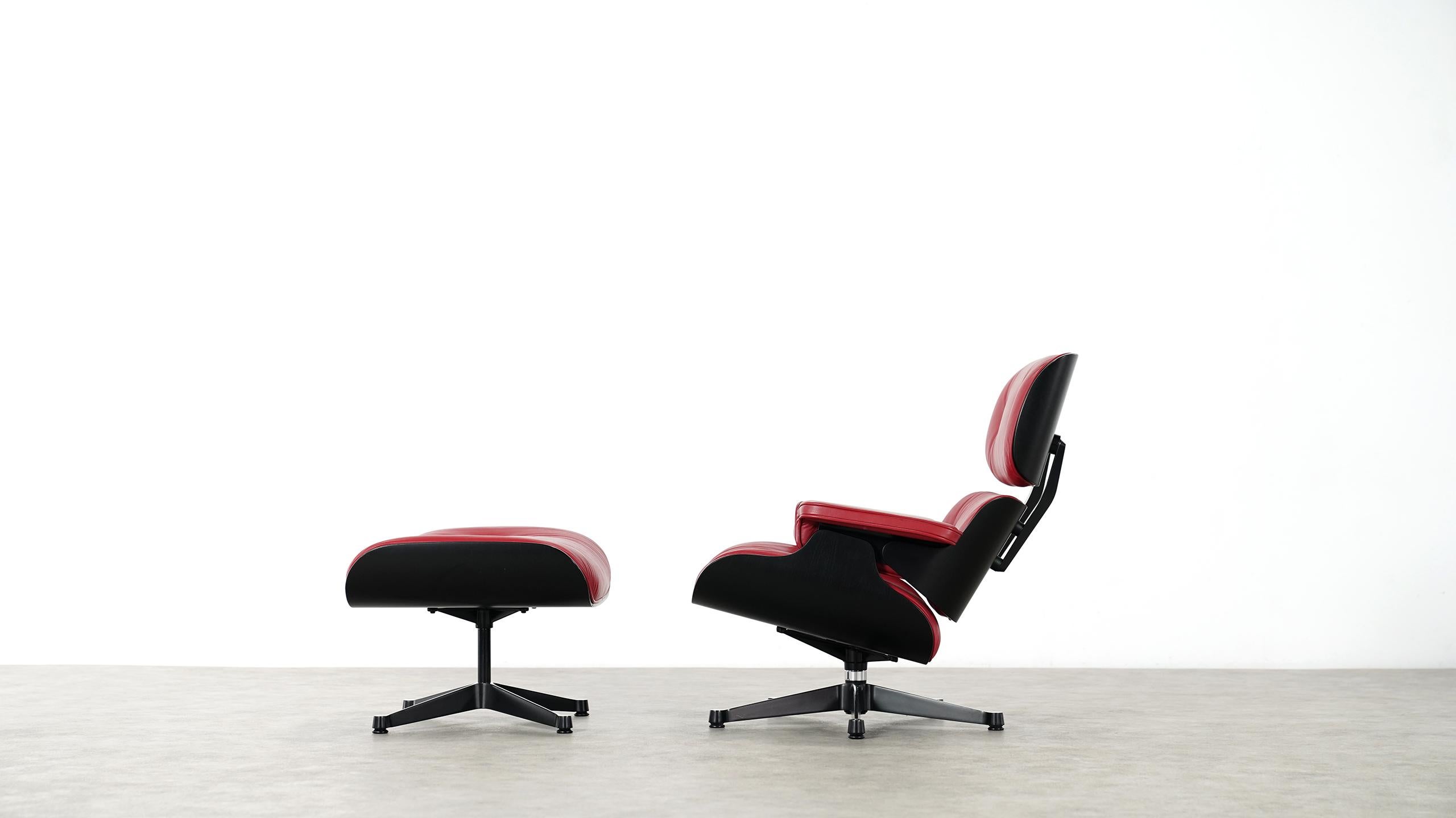 Stunning and beautiful Charles Eames lounge chair and ottoman by Vitra.
With smoothened black shells, so the wood grain is perceptible and very soft red leather pads.

Very nice condition!

Both, chair and ottoman have their original