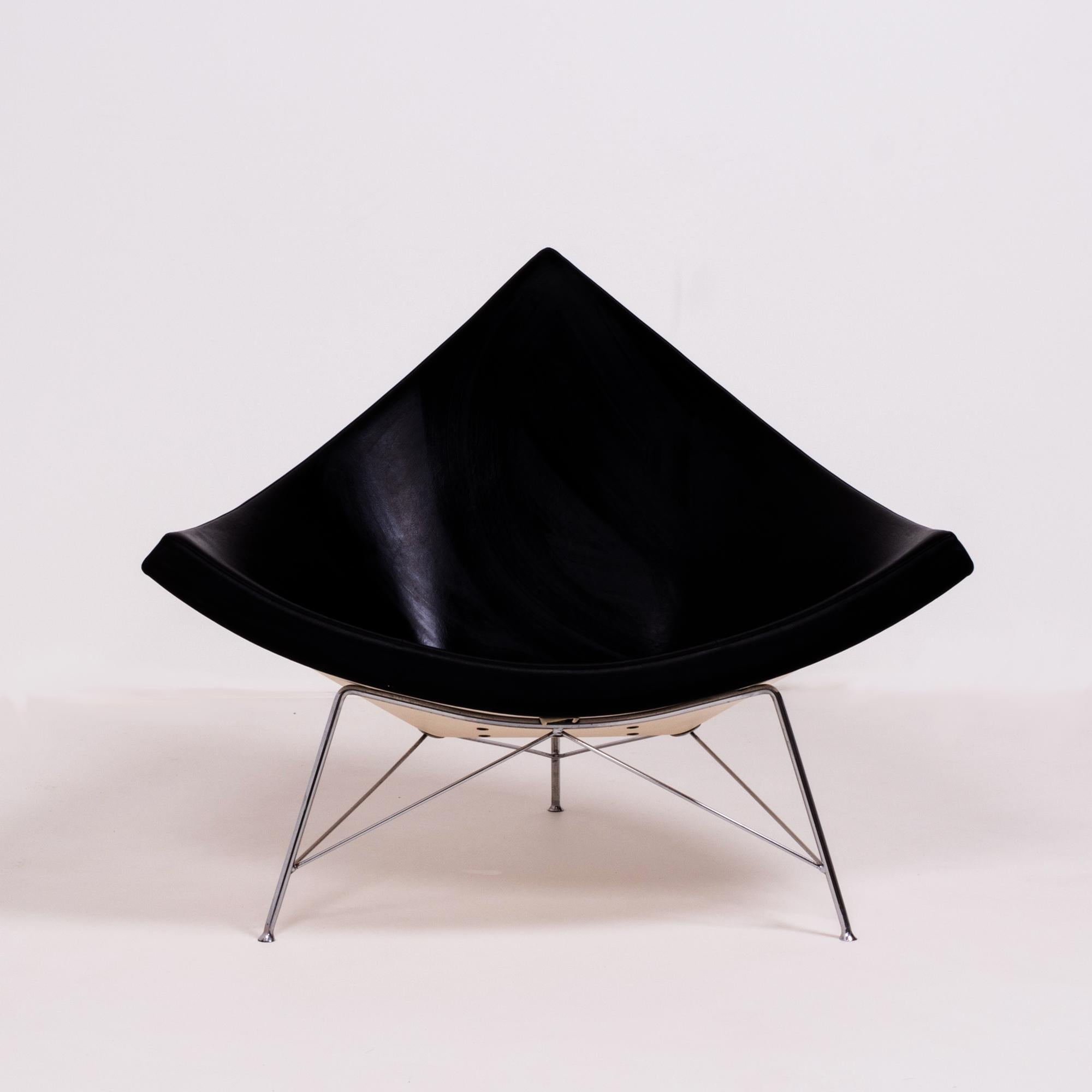 Originally designed by George Nelson in 1955, the Coconut chair has become a design Classic.

Constructed with a white glass fibre reinforced plastic shell, the chair is upholstered in black leather with a tubular steel base in a polished chrome