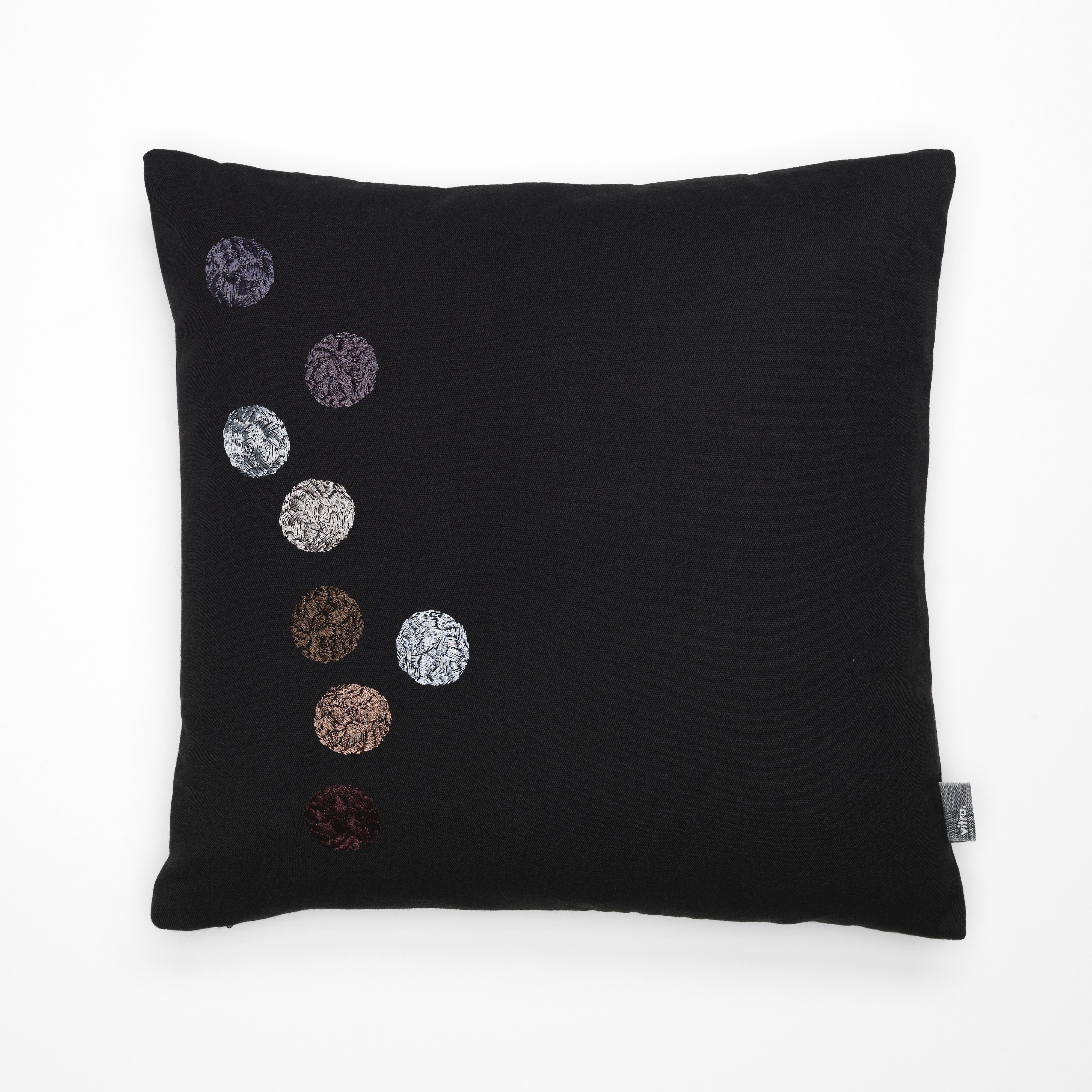 The Dot Pillows are adorned with a series of individual dots, each of which is embellished by an irregular hachured pattern that appears to have been embroidered by hand. This handcrafted effect is characteristic of work by Dutch designer Hella