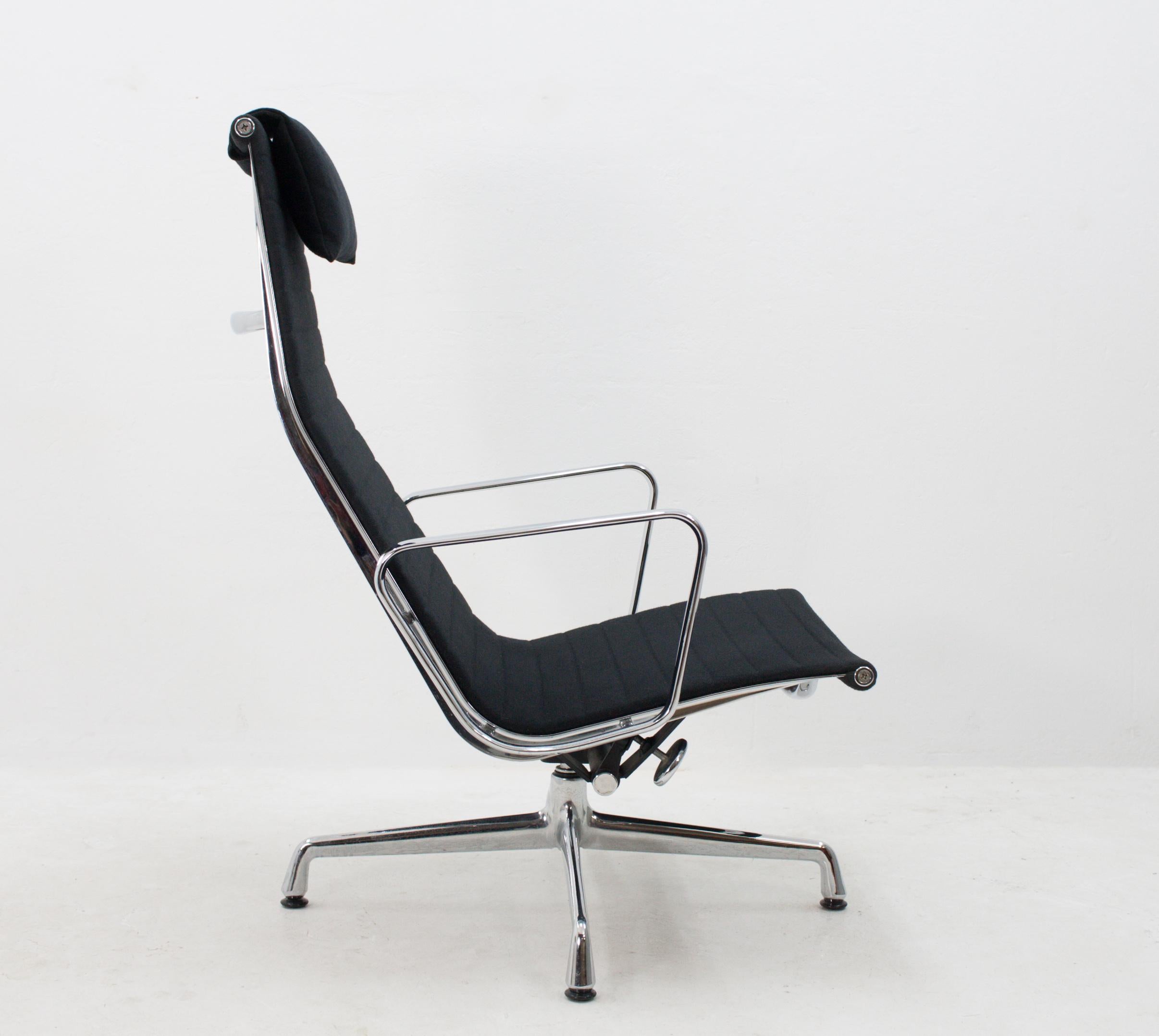 Wonderfully sleek Swiss-built Eames EA116 lounge chair upholstered in characteristic black hopsack fabric. This chair is in good condition and features the optional headrest cushion. With the swivel option .