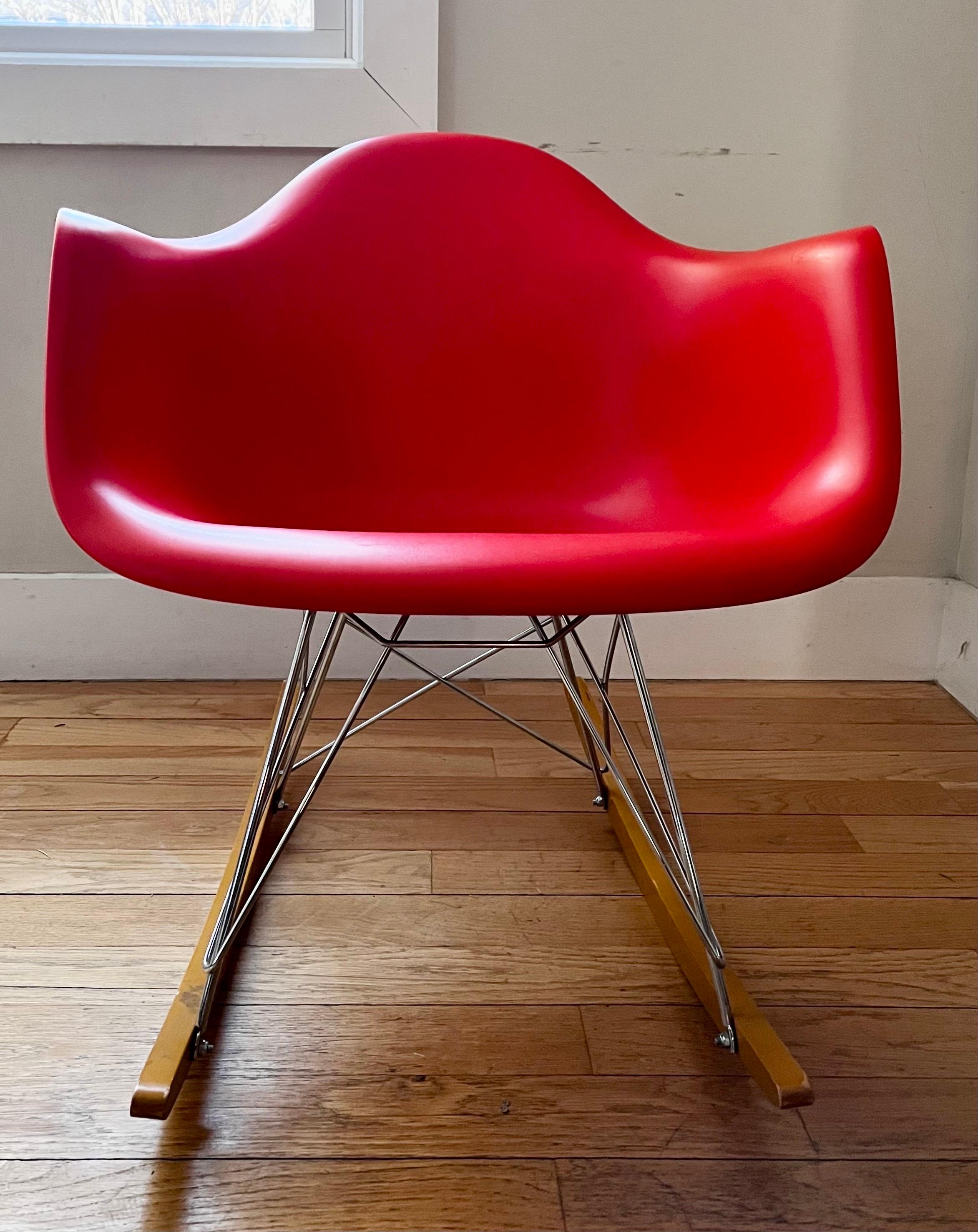 Poltrona Eames in plastica Vitra Production (RE RAR) 
di Charles & Ray Eames

Scocca rosso papavero con base a cupola e dondoli in acero dorato

