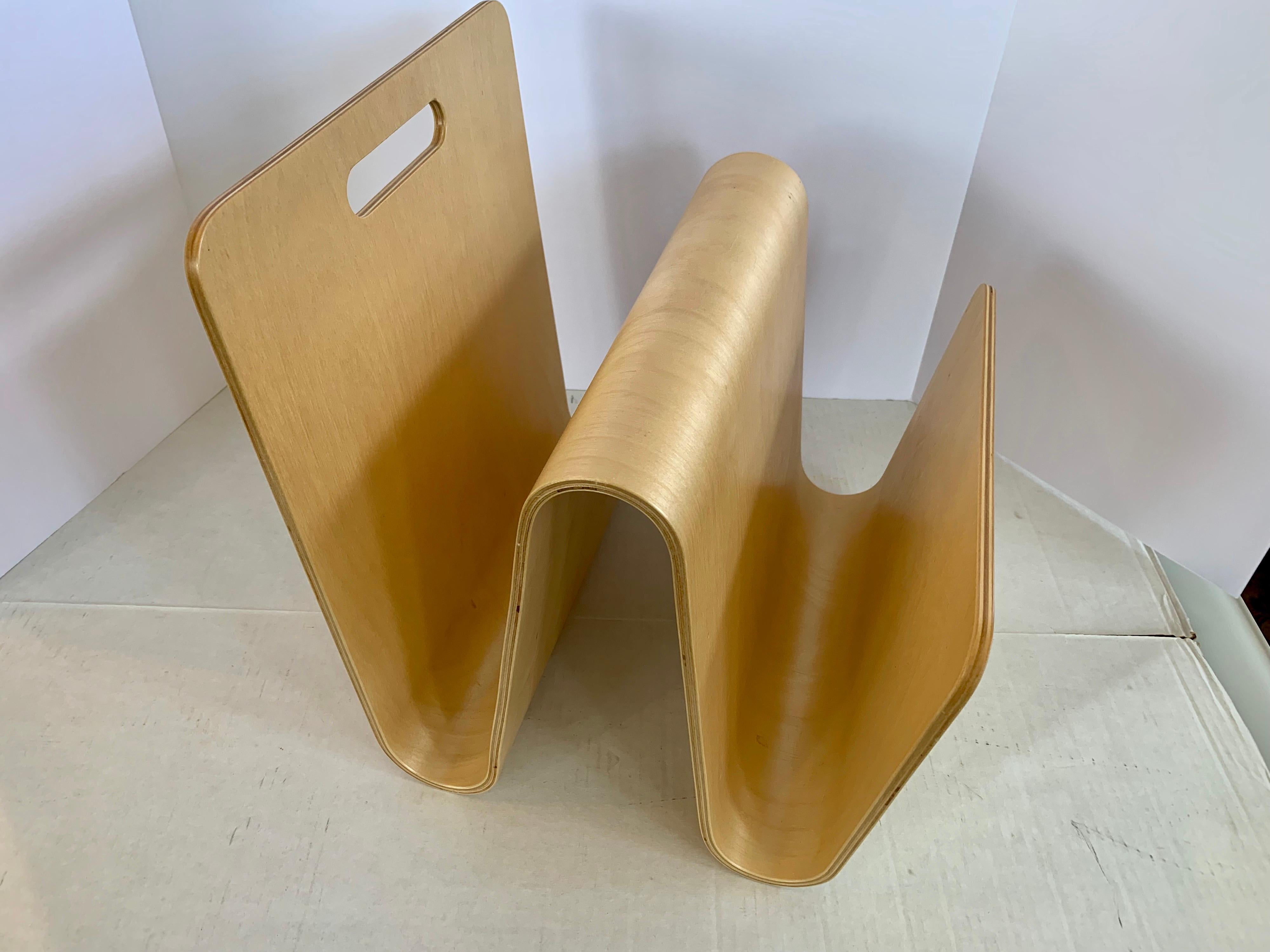 Made of molded maple plywood, this curved Sori Yanagi magazine rack for Vitra is a joy to look at.
It has a hollow handle at top for ease of mobility. 
     