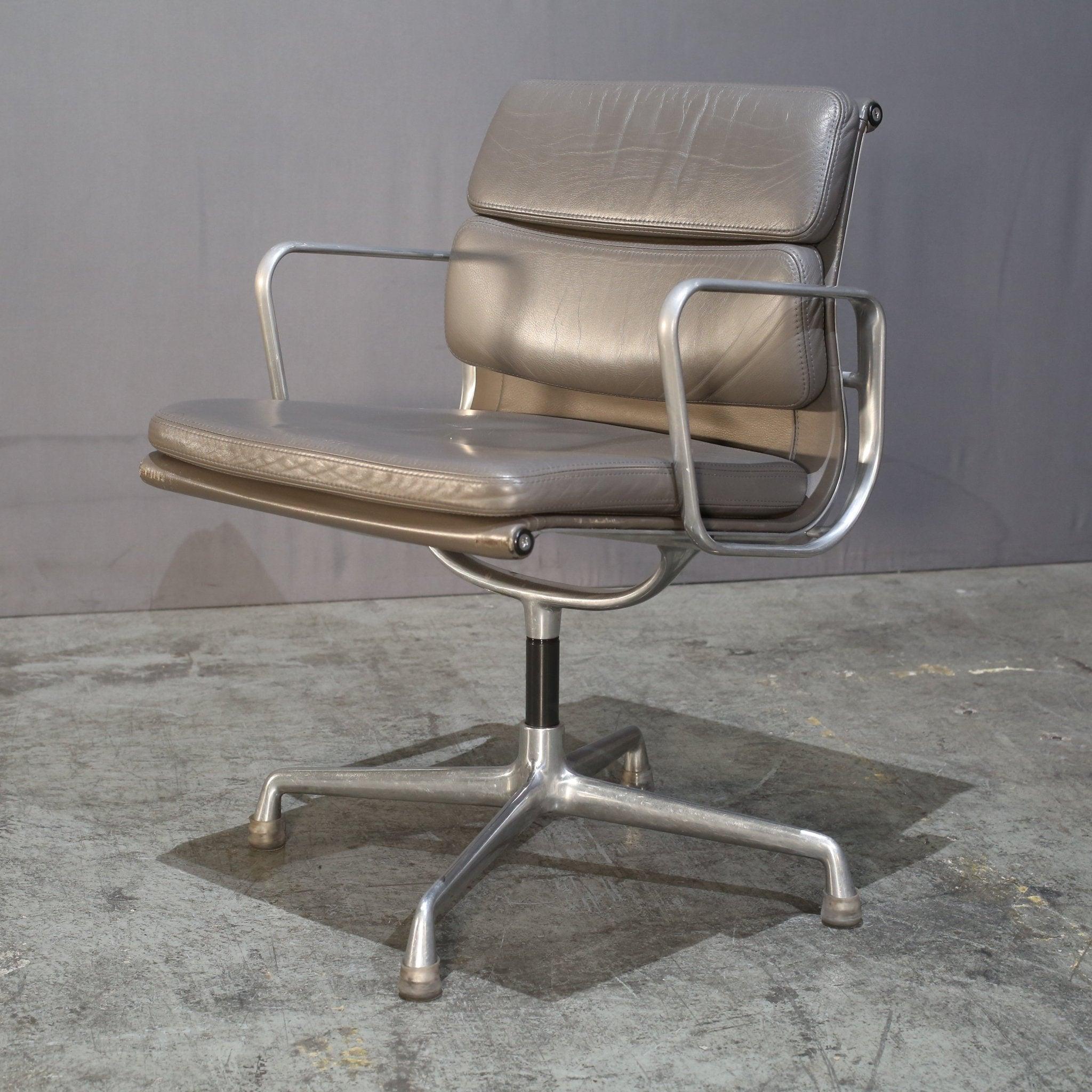 Introducing the iconic Soft Pad EA208 Chair by renowned designers Charles and Ray Eames for Vitra. This luxurious chair features a sleek and sophisticated design, with a polished metal frame and soft padded leather upholstery. The ergonomic design