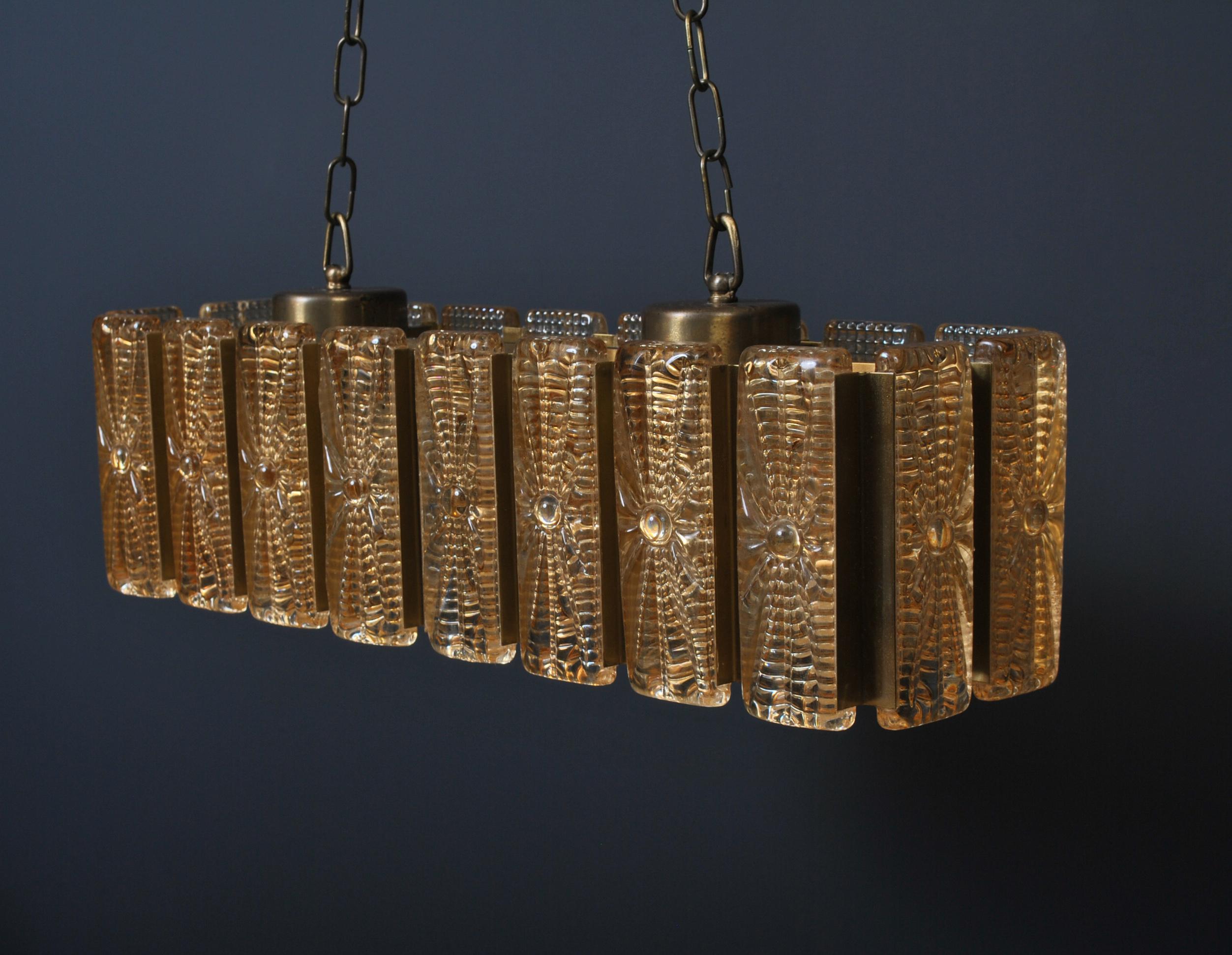 Glass and brass rectangular pendant chandelier light by Vitrika Design, Denmark circa 1960. Golden hue glass blocks with clear inner cut glass cylinders. Current drop with chain is 110cm but can be adjusted.