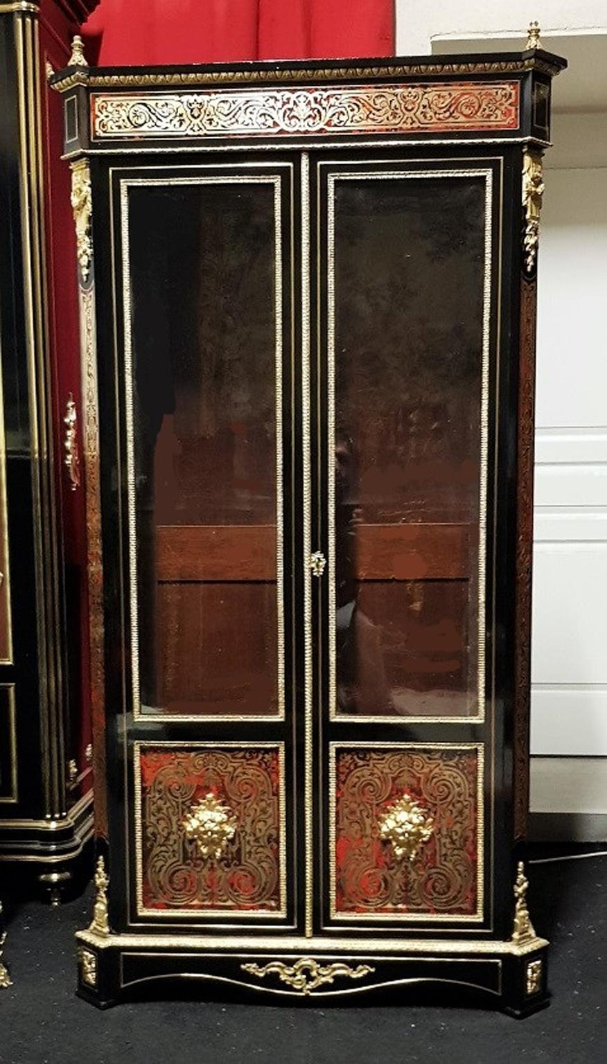 Beautiful Vitrine Bookcase in Boulle style marquetry in brass and tortoise shell, with motifs of foliage, volutes and tracery.
Rich ornamentation of gilt bronze and masks of Faun on the doors.
The interior side is in mahogany with 4 adjustable