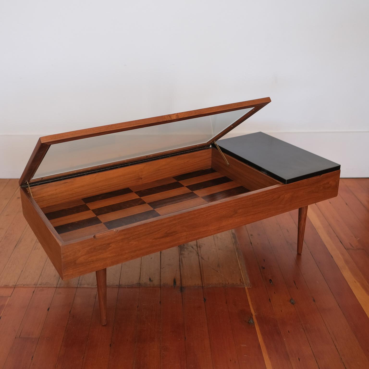 Walnut and rosewood coffee table by Stewart MacDougall for Glenn of California. There is a vitrine side for display and a divided storage area is under the black laminate. Both sections of the table open with discreet piano hinges. This is an