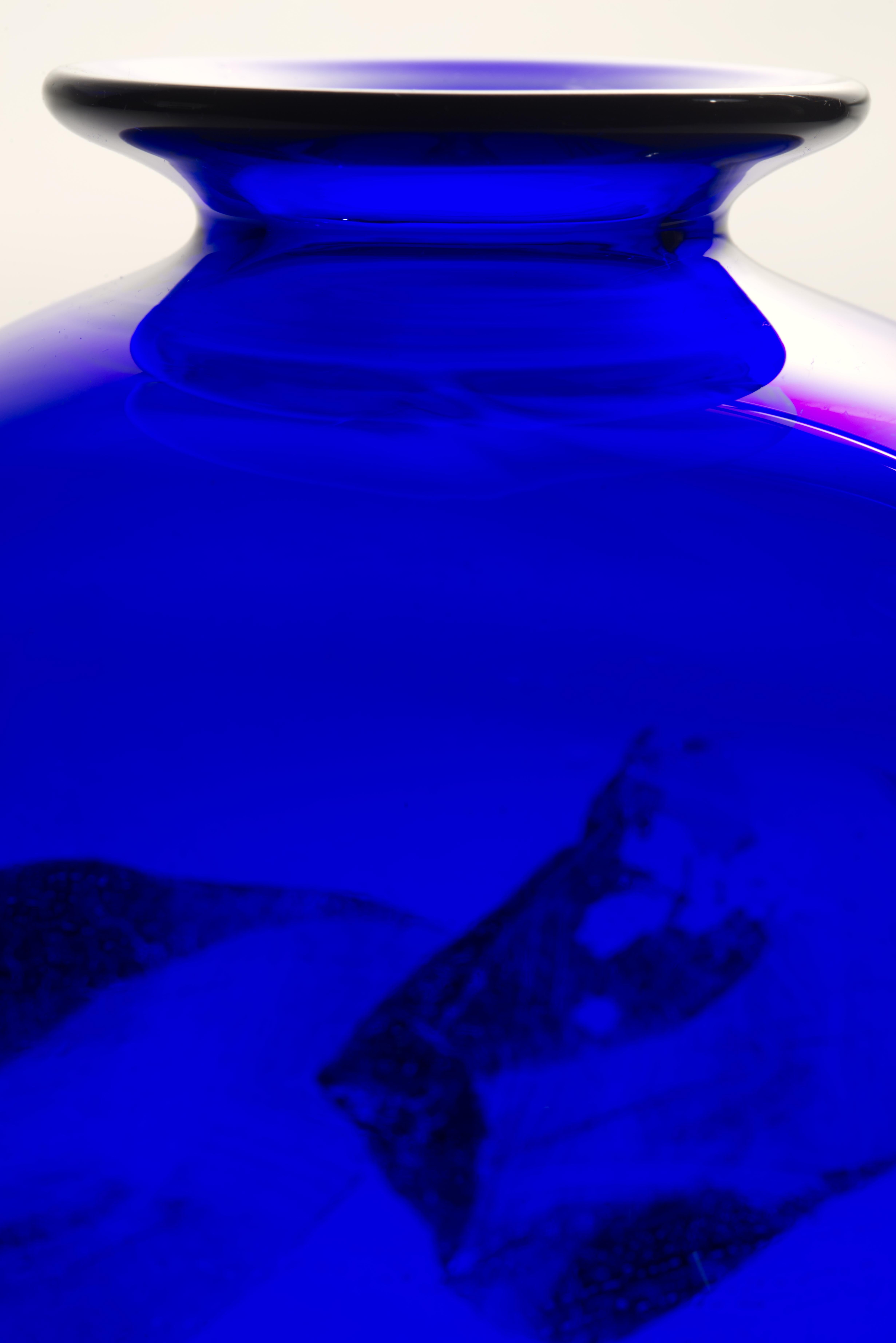 Sculptural Organic Modern vase was hand blown with thin layer of gold foil fused over cobalt blue glass. The abstract, graphic pattern is swirling around the curves of the vase; the whole structure is enclosed in thin layer of clear glass in