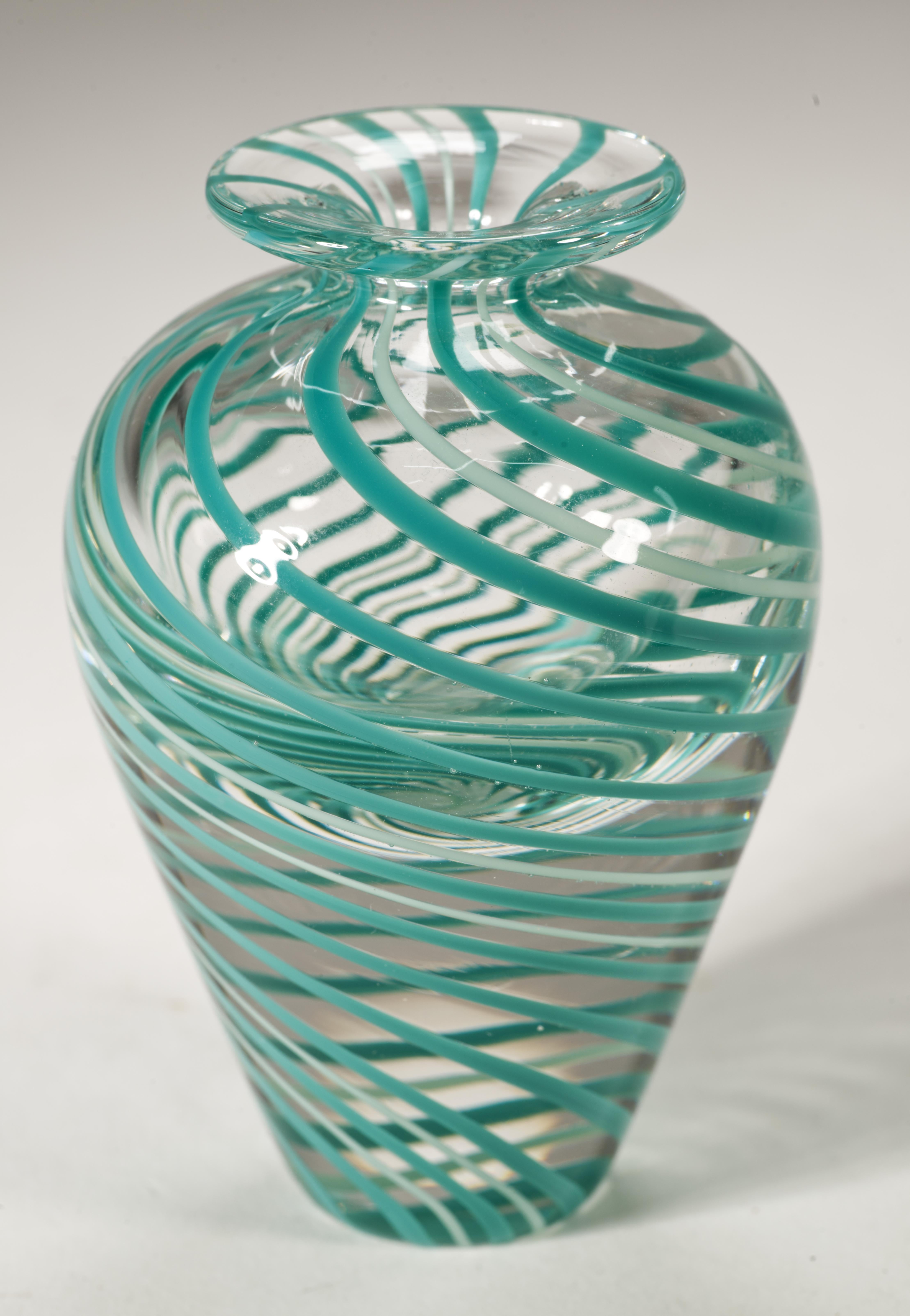 Ce rare vase à bourgeons en verre fusionné présente des tourbillons colorés de verre bleu sarcelle et blanc cassé placés dans un motif graphique abstrait le long des lignes de la pièce, l'ensemble de la structure étant enfermé dans du verre clair