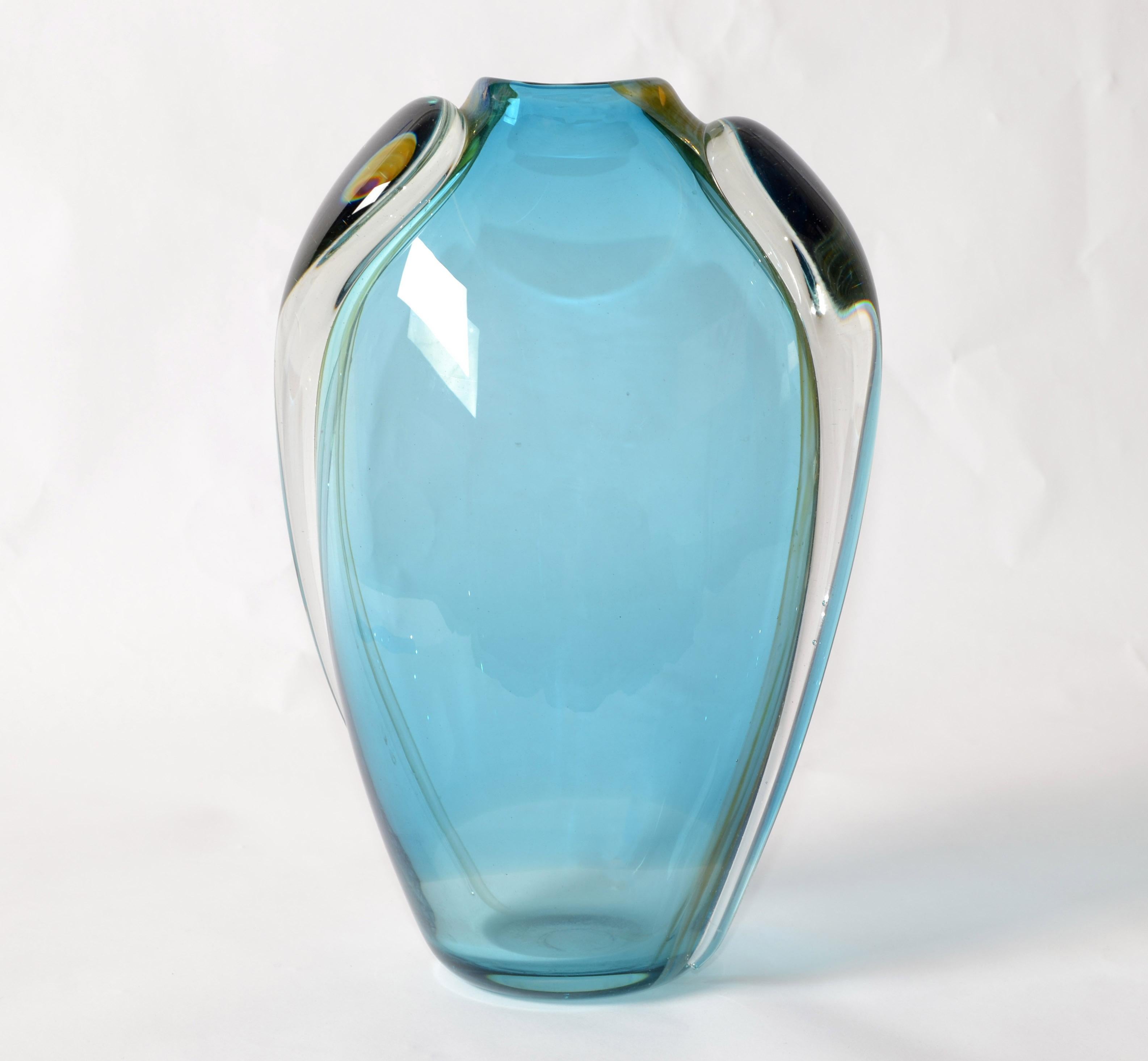 Artist Thomas Buechner III created this beautiful studio piece of hot blown art glass vase in light blue, gold and transparent color.
Mid-Century Modern Op Art made in 1980 at the Vitrix Studio in America.
In good vintage condition with some wear