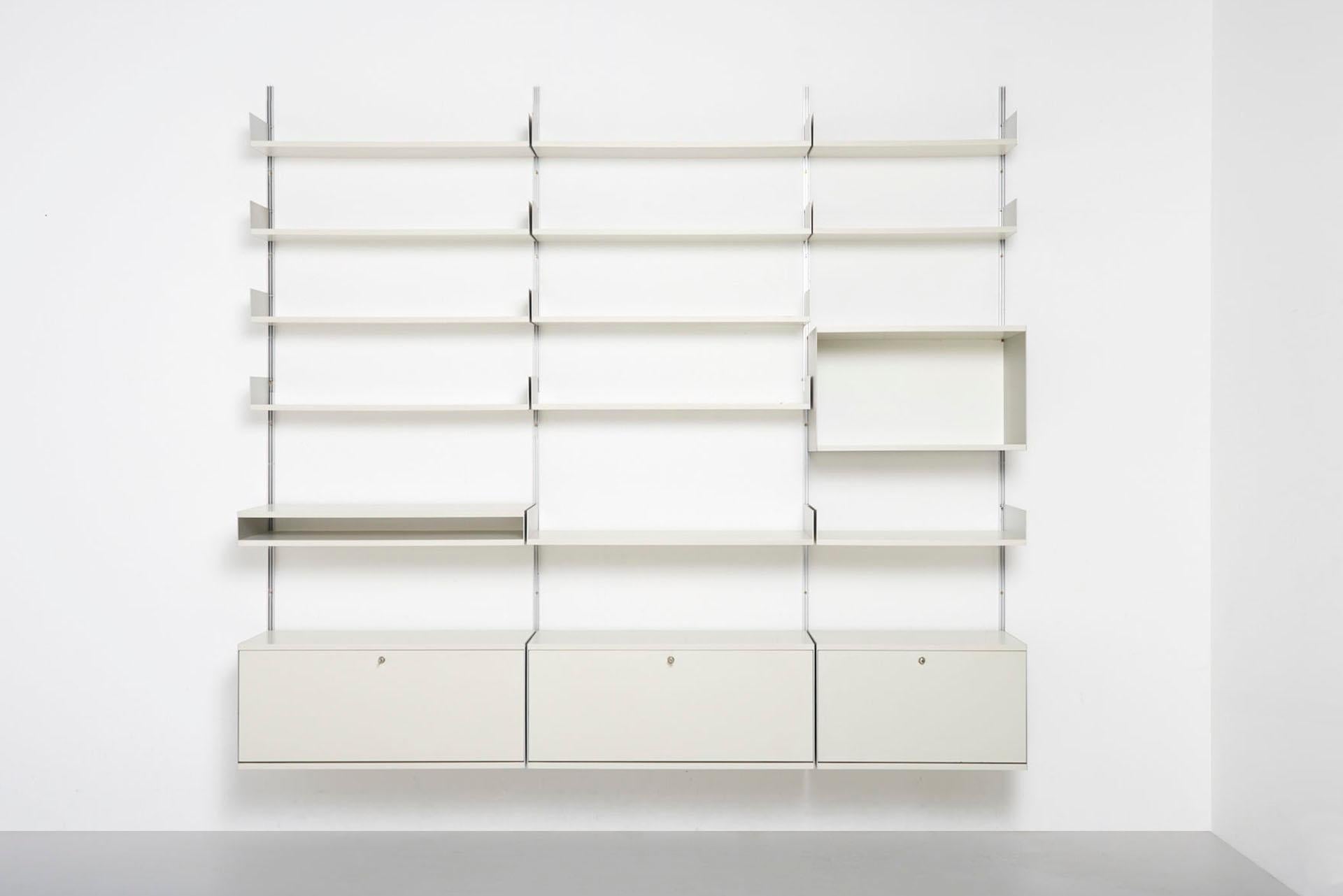 A large wall system made by Vitsoe in Germany. Design by Dieter Rams in 1960. This model 606 shelving system comprises 3 cabinets with lock, an open upper cabinet, 3 deep shelves and 10 standard shelves.