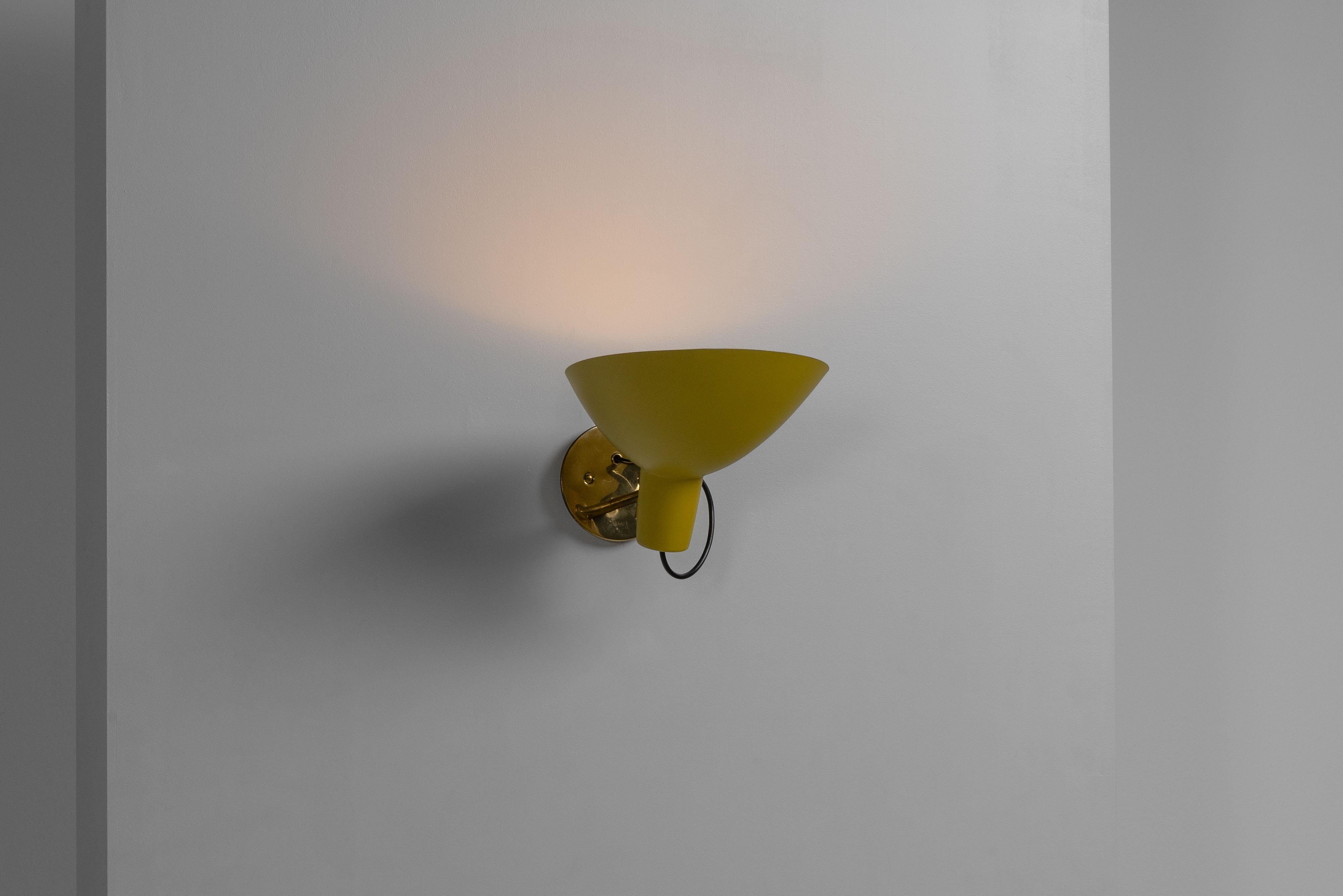 Très rare applique modèle 2 conçue par Vittoriano Vigano, supervisée par Gino Sarfatti et fabriquée par Arteluce Italie 1950. Cette applique est rare en raison de sa finition jaune moutarde. La lampe consiste en une plaque ronde en laiton fixée au