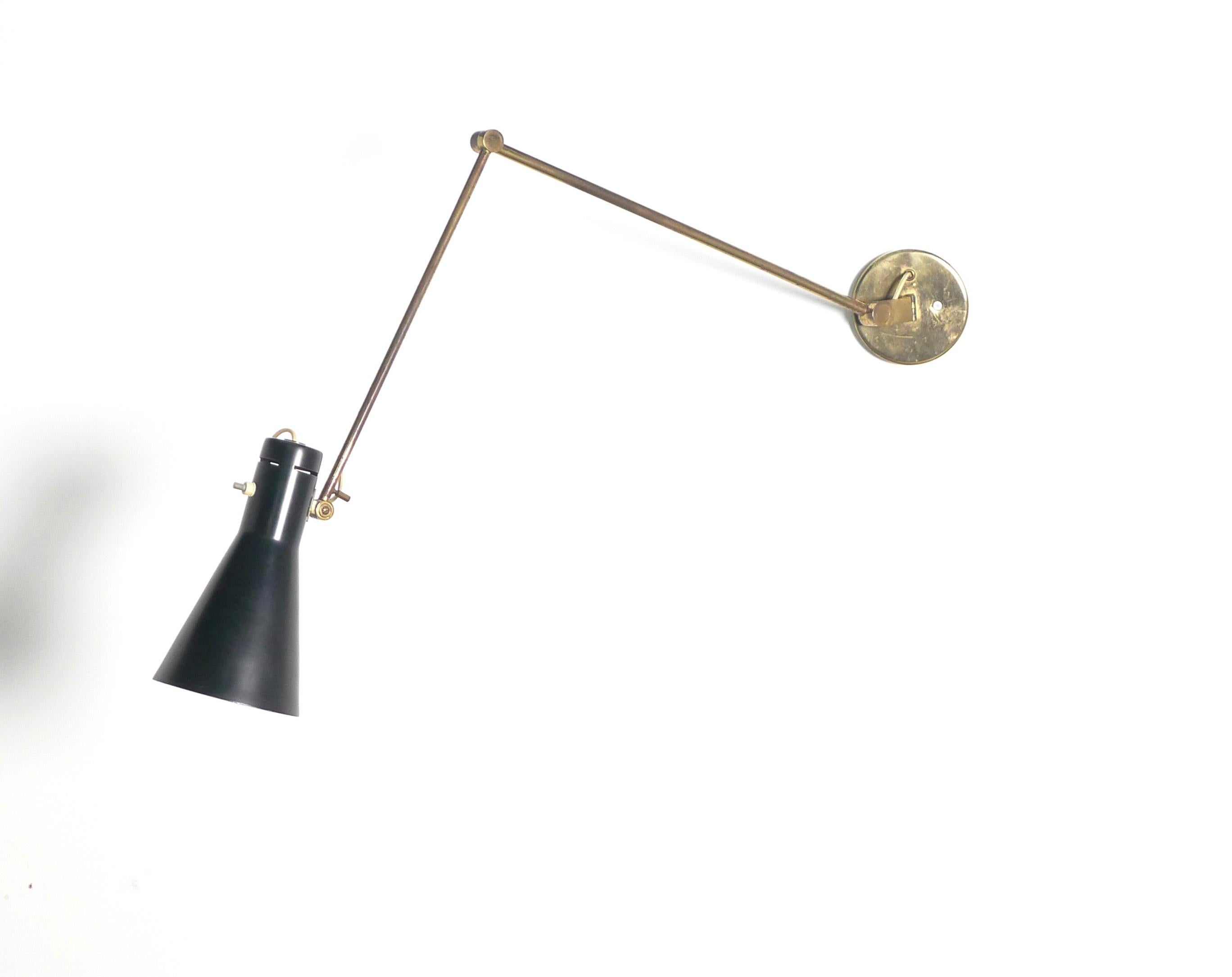 This is a rare design, featuring Vigano's distinctive conical shade mounted on an articulated brass arm with circular wall mount. The hinged arm allows the shade to be moved in multiple directions, rotating and pivoting to point the light where