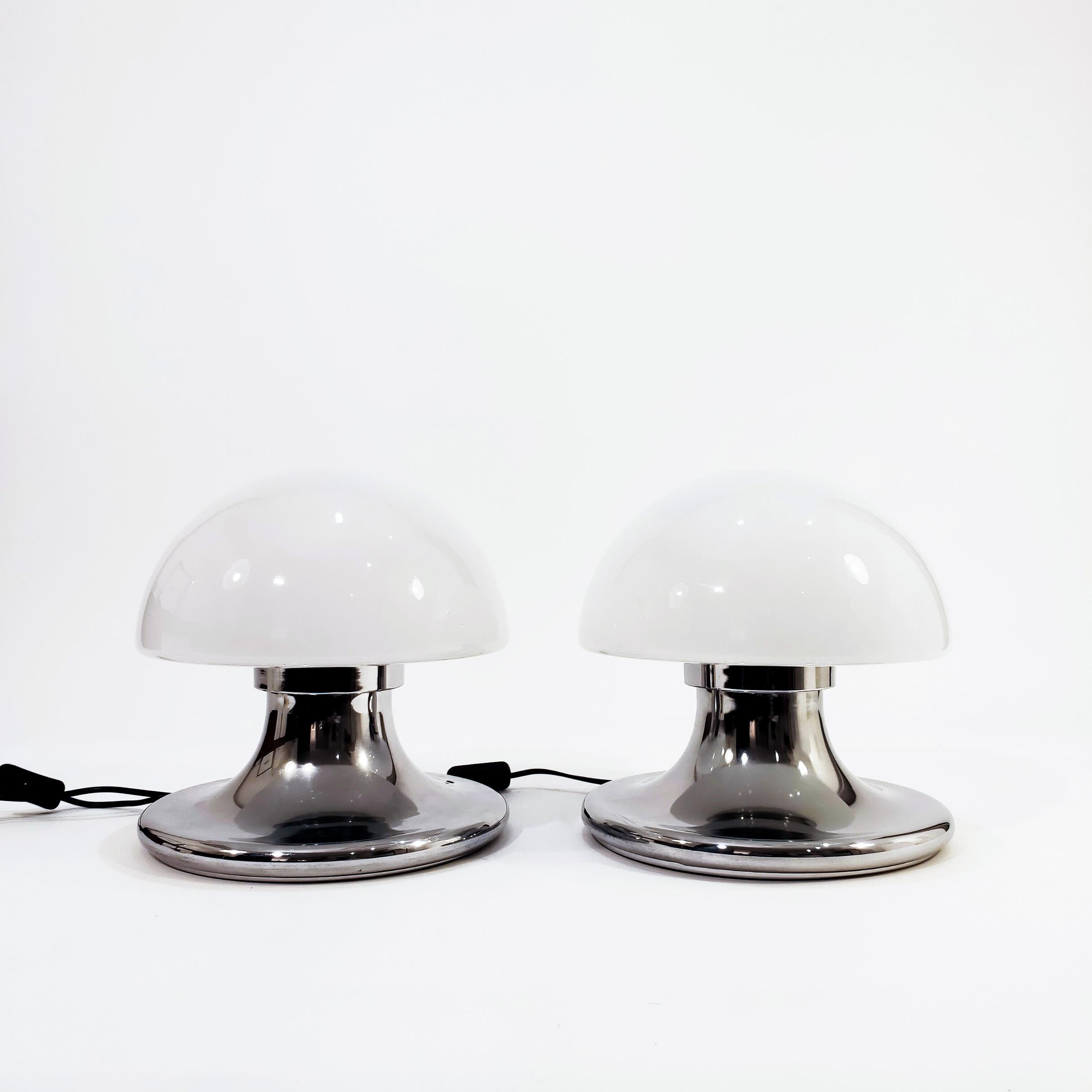 Coppia di lampade da tavolo italiane a fungo Space AGE degli anni '70. La struttura è realizzata in acciaio cromato color argento, con un paralume in vetro opalino. Molto simile allo stile delle lampade di Vittorio Balli e Romeo Ballardini per