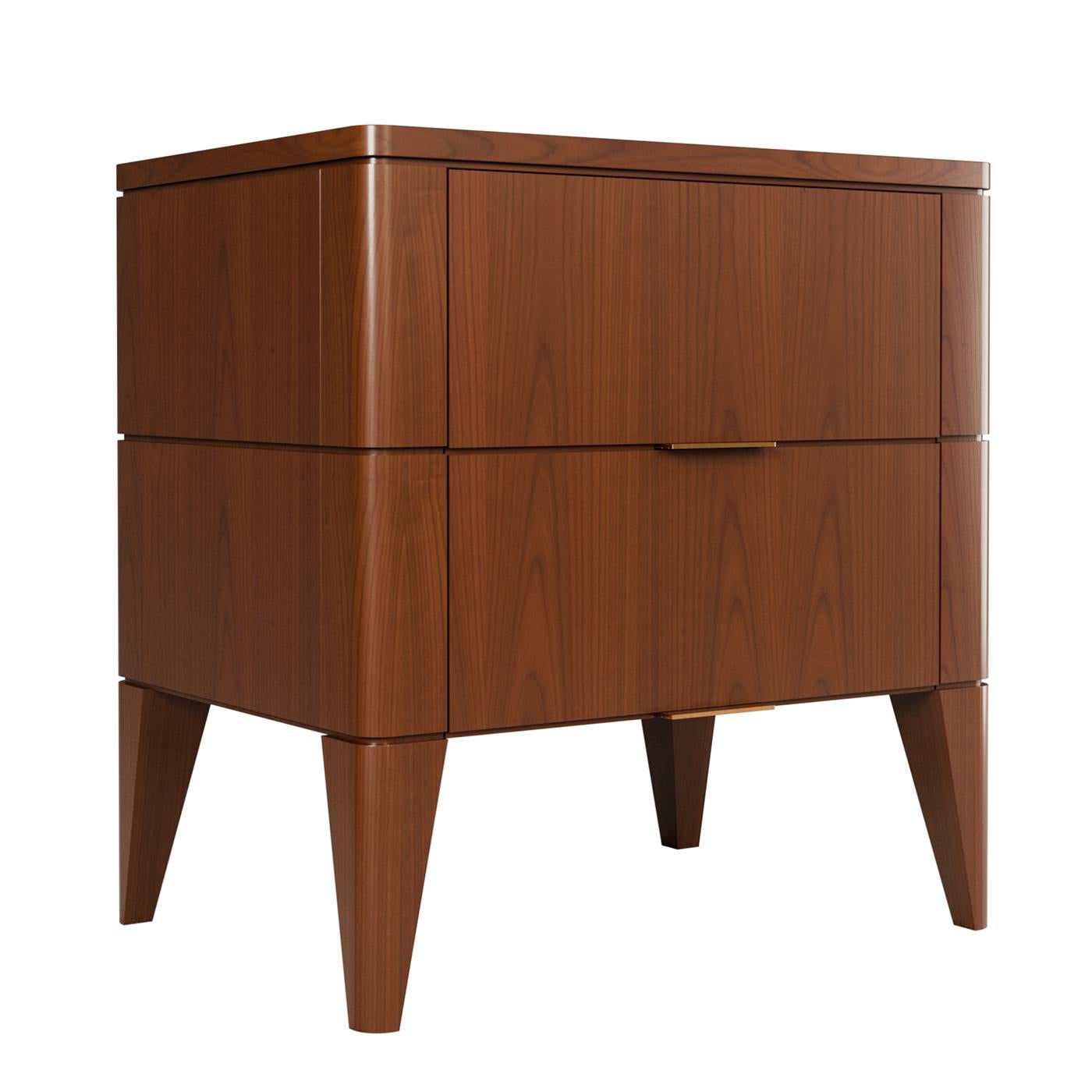 Il comodino Vittorio è caratterizzato da un design raffinato con due cassetti che presentano una dettagliata fresatura sul fronte e sui lati. Le sue gambe a spillo danno un tocco di eleganza, mentre le sottili maniglie in ottone aggiungono un
