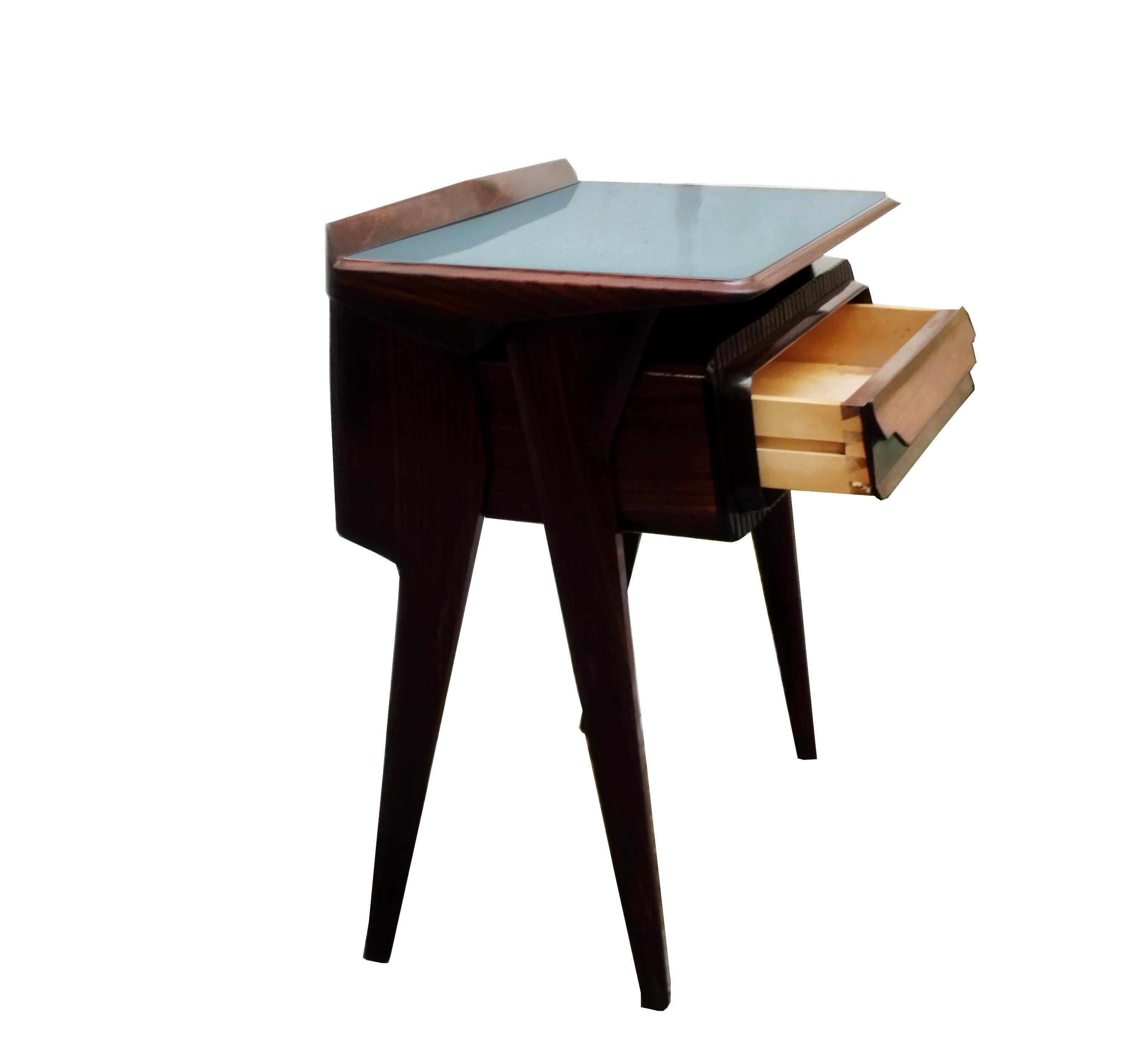 Wooden bedside table designed by Vittorio Dassi in the 1950s.
 Its aesthetic uniqueness lies in the original sculptural design of the shape of the drawer and the side supports, as well as the green glass top surmounted by a long, thick transparent