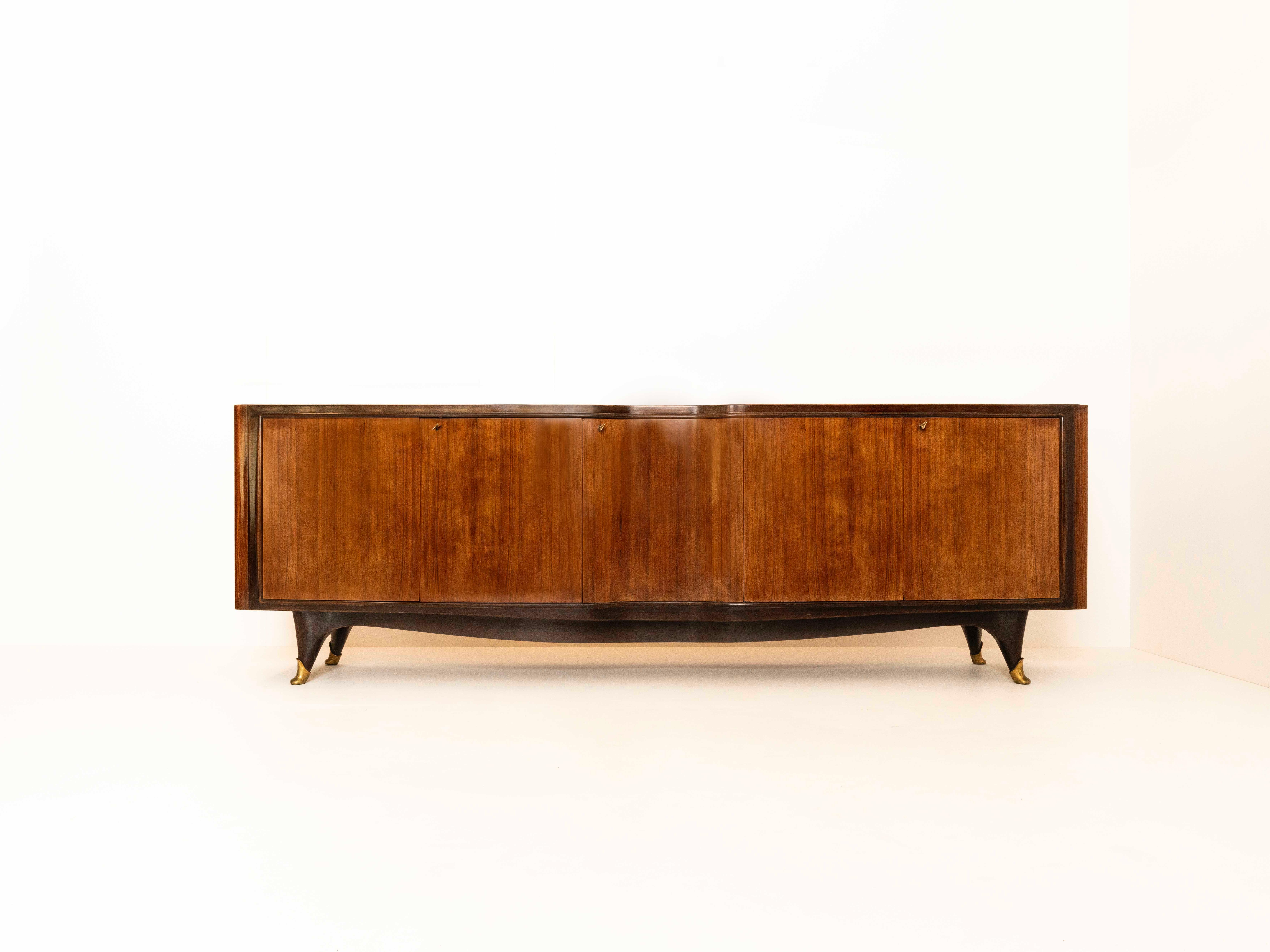 Large Vittorio Dassi Credenza in Wood, Glass and Brass from Italy, ca the 1950s. This is a true eye-catcher. It has five doors with shelves behind it and three original keys available. The top is made of glass with underneath an 'orange' color and