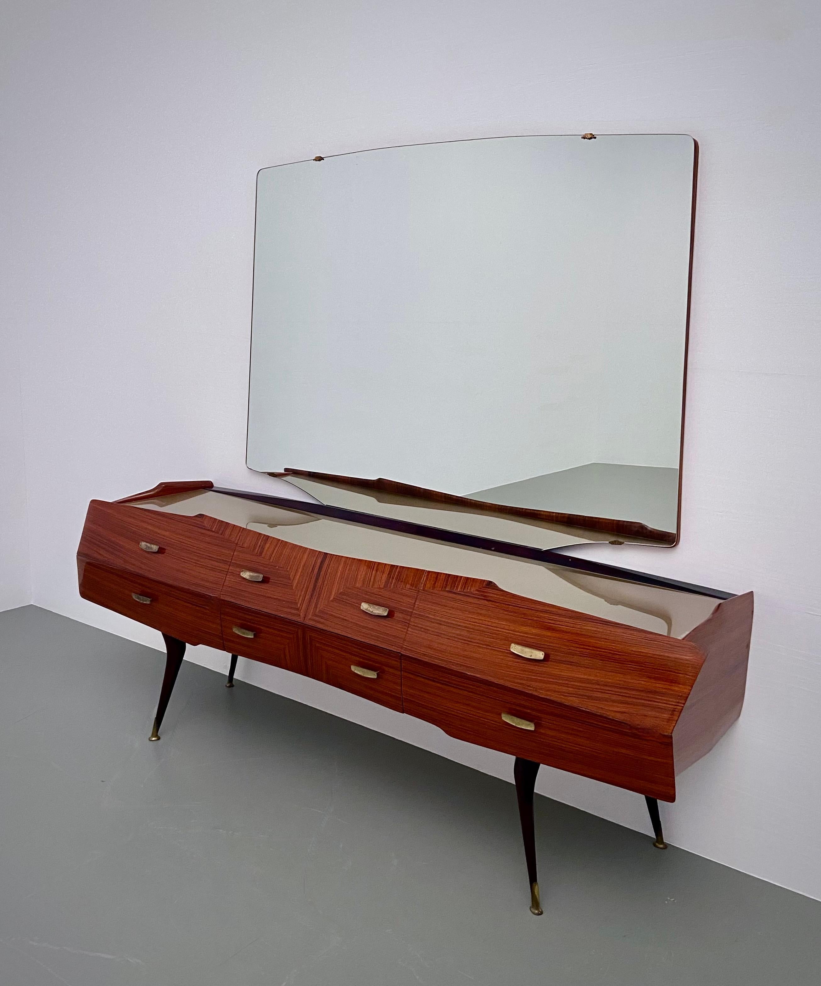 Typical Vittorio Dassi credenza with its futuristic shapes and shiny appearance. Some sort of spaceship but then with mirror to see how beautiful you are. Shiny, outspoken and luxurious all resting on bended ballerina legs (with brass feet) that are