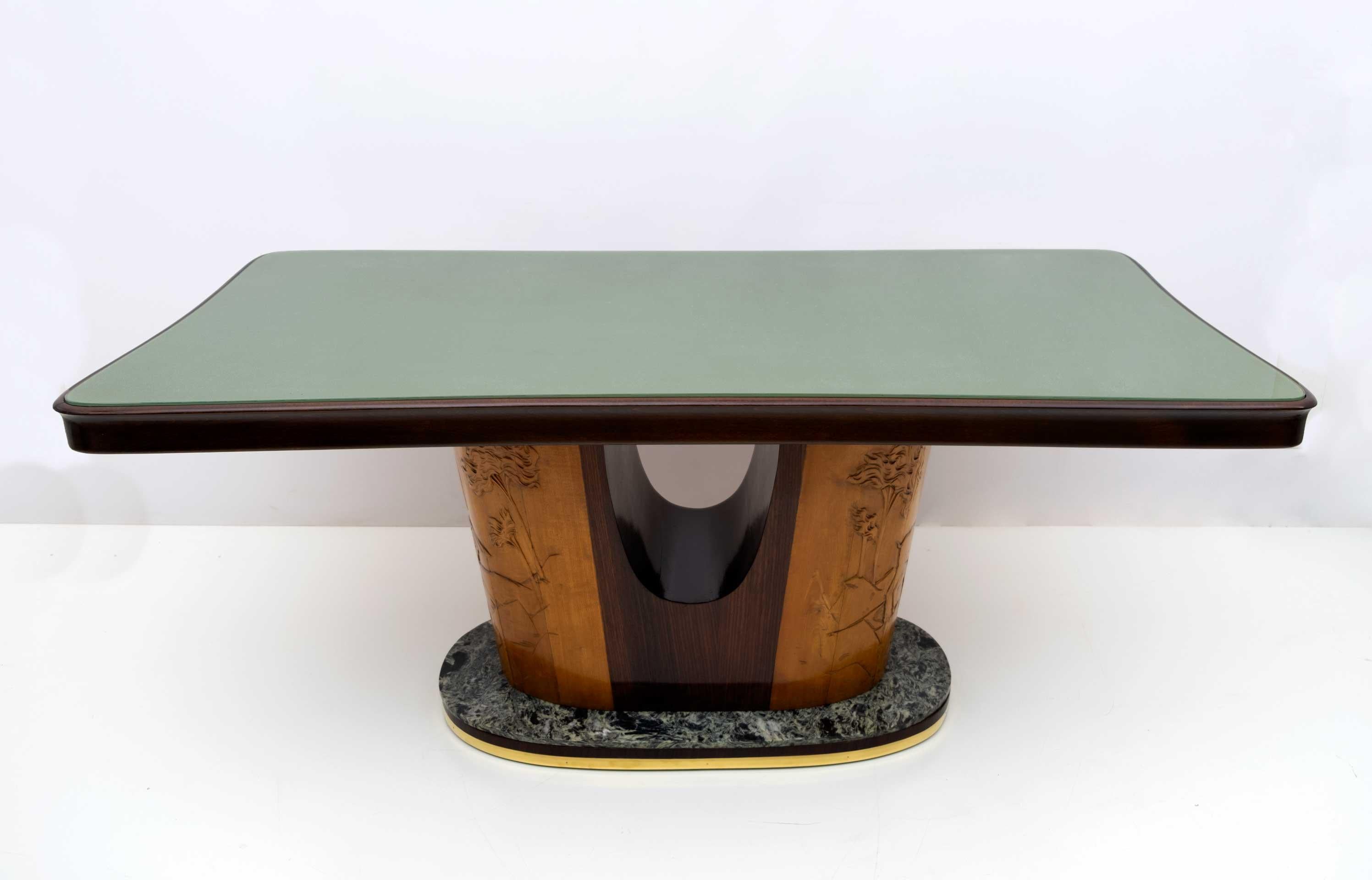 Magnifique table conçue par le célèbre designer italien de style Mid-Century Modern, Vittorio Dassi, 1950.
Les boiseries exceptionnelles sont mises en valeur par le plateau en verre vert incurvé et les bords arrondis de la structure. Cette pièce de