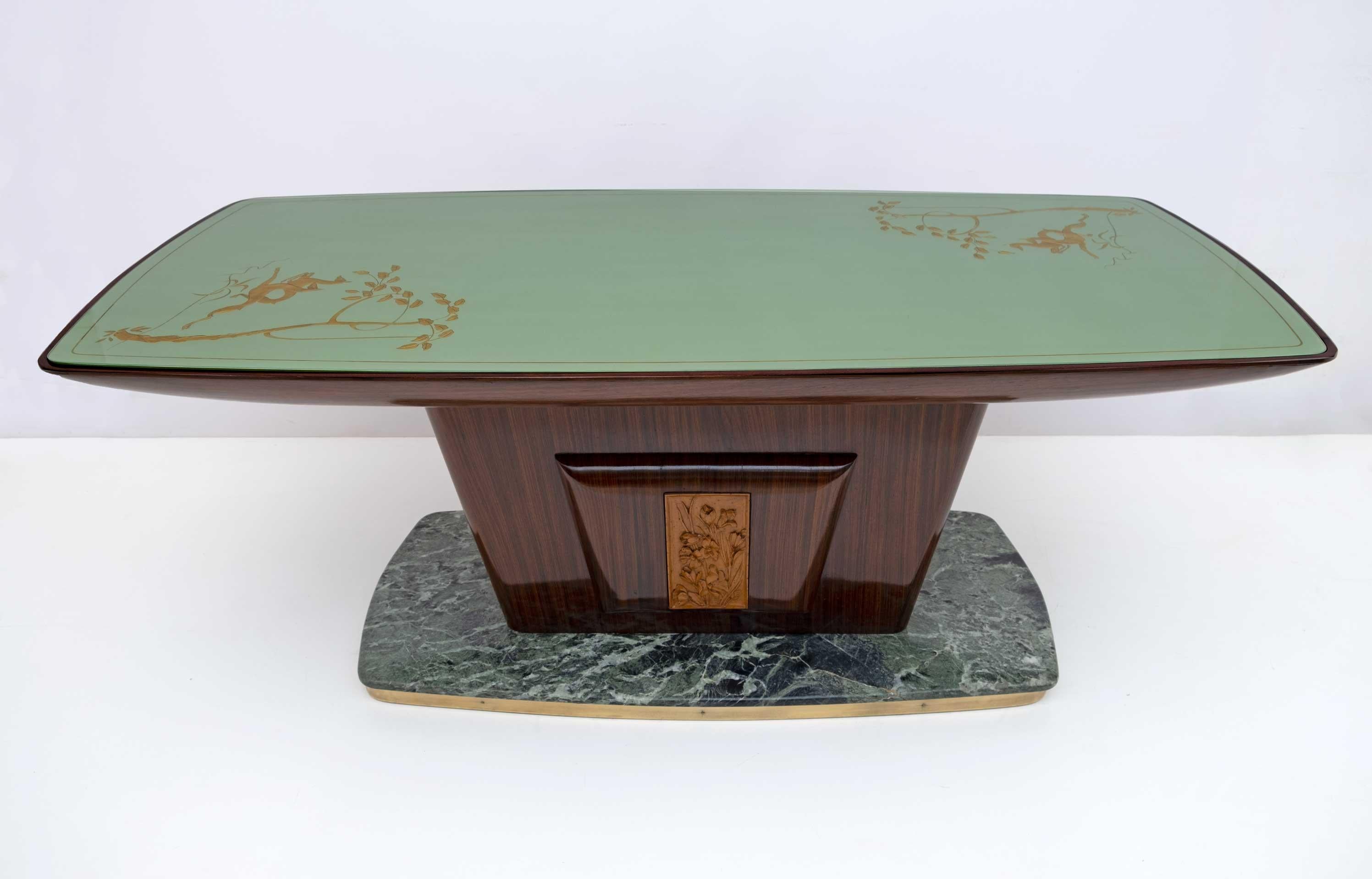 Magnifique table conçue par le célèbre designer italien de style Mid-Century Modern, Vittorio Dassi, 1950.
Le travail exceptionnel du bois est mis en valeur par le plateau en verre vert incurvé avec des décorations en feuilles d'or et les bords