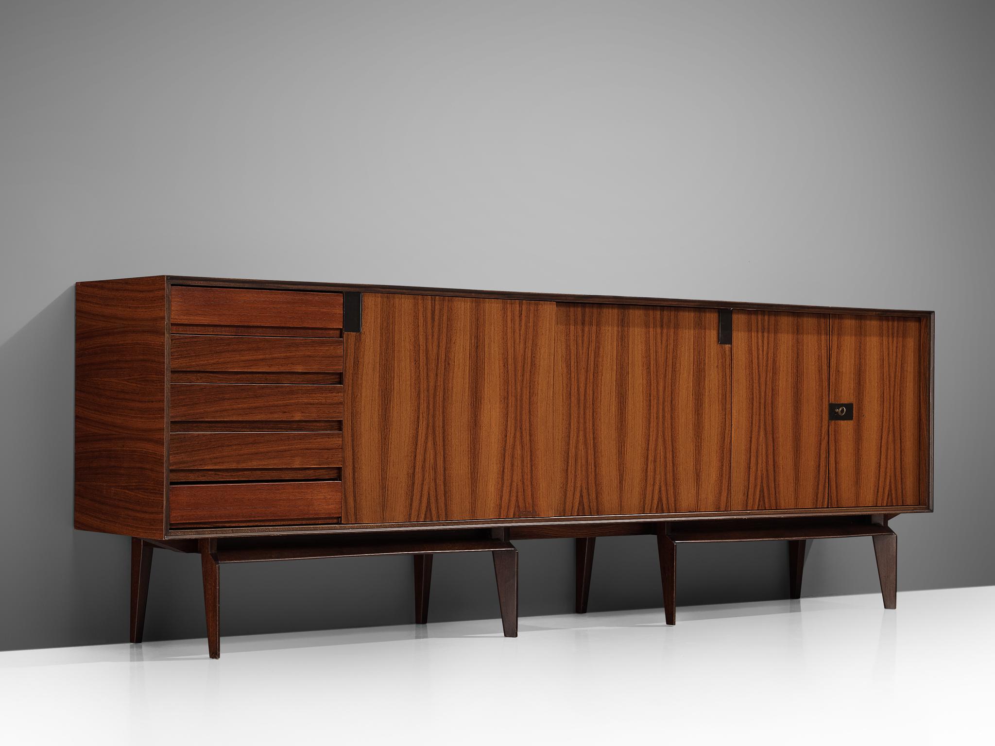 Vittorio Dassi, sideboard, rosewood, Italy, 1960s. 

This special console is finished with superb rosewood veneer which has been completely restored by our specialized craftsman. The nicely patineted, subtle brass grips and the eight tapered legs