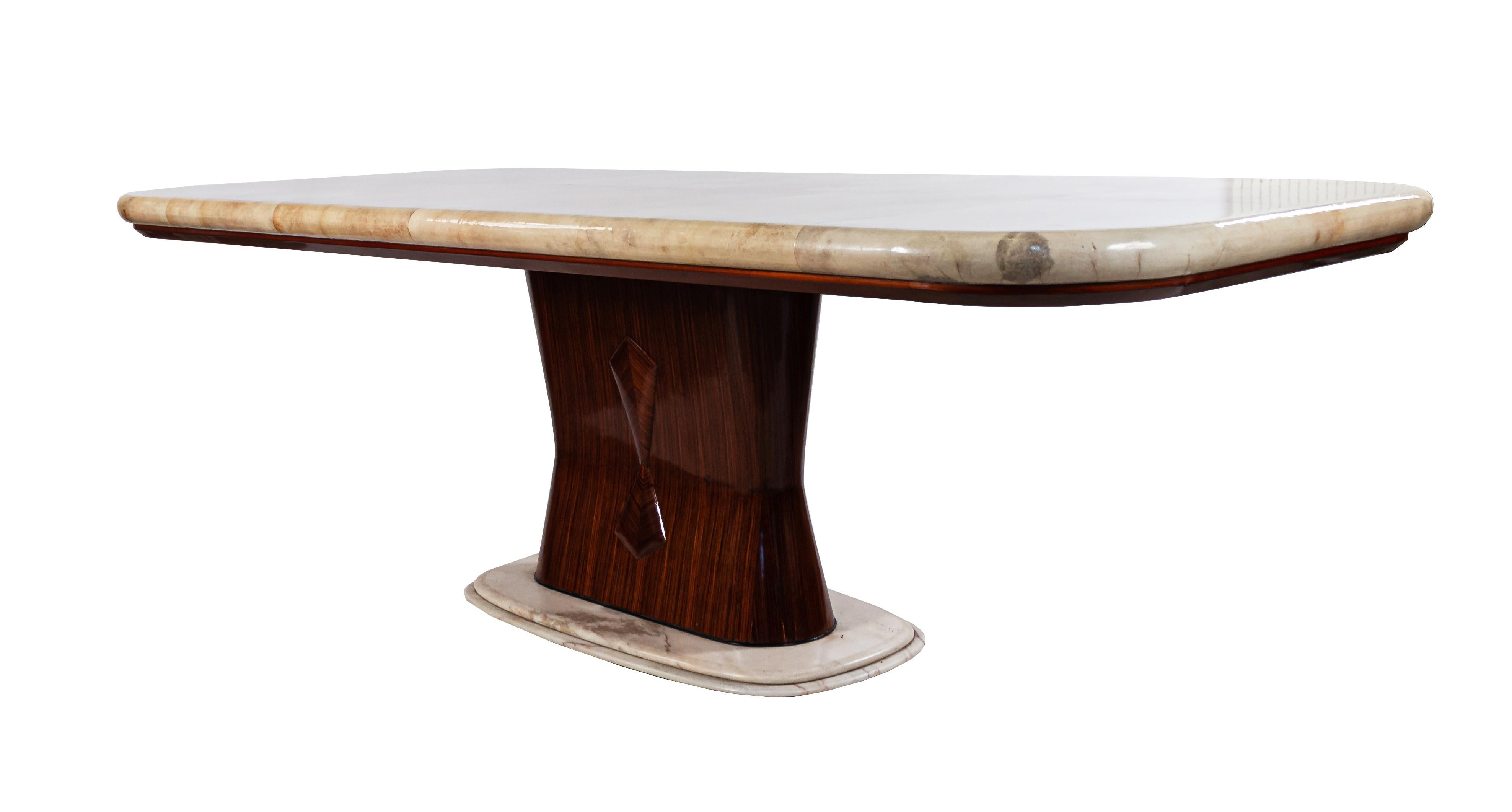 Italian midcentury dining table with a parchment top having rounded corners on an hourglass-shaped rosewood pedestal base with carved diamond detail on an oval white marble foot (attributed Vittorio Dassi).
