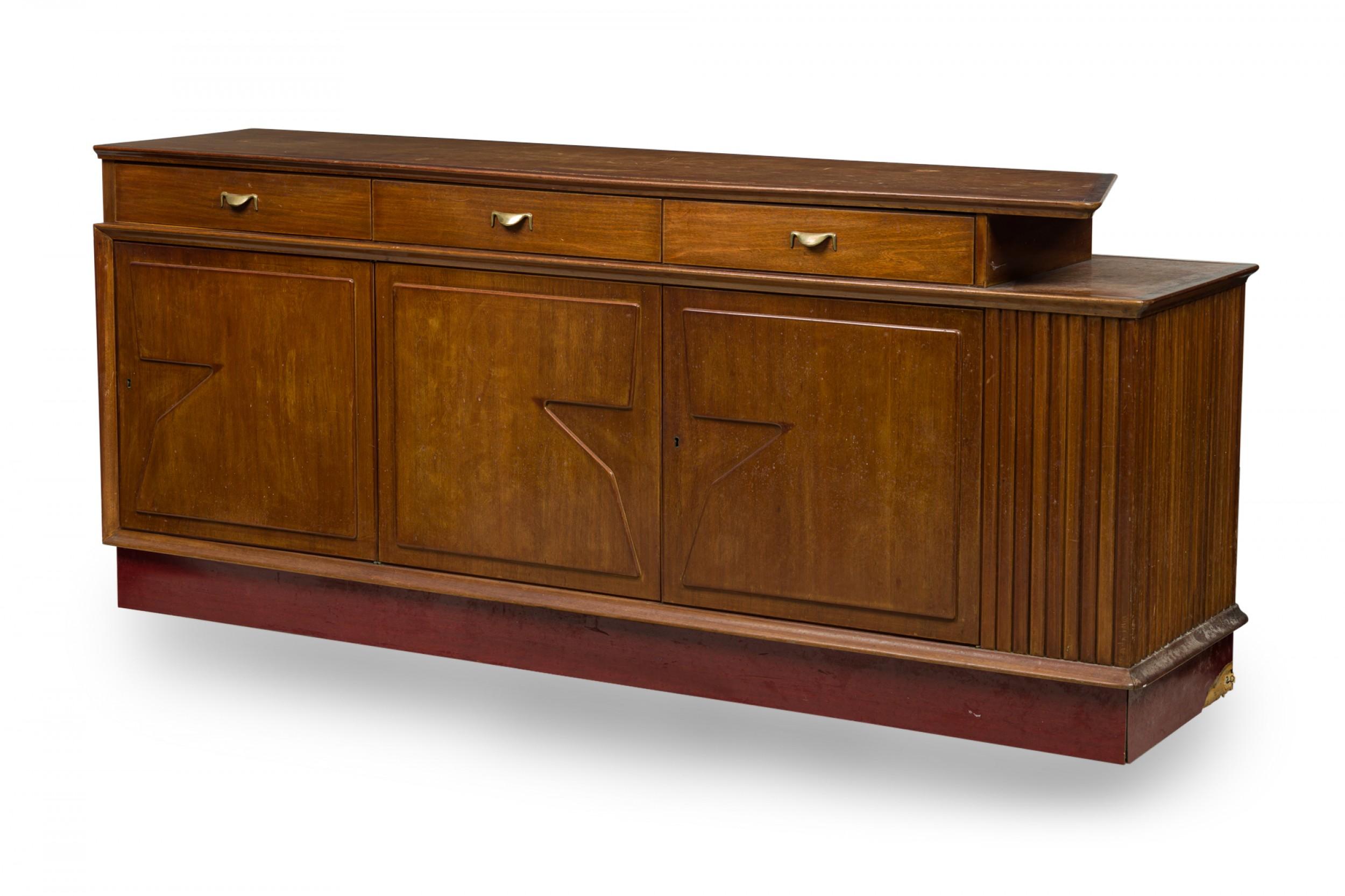 Midcentury Italian Modern buffet / room divider / credenza with a walnut case featuring three upper drawers with brass drawer pulls over three hinged cabinets with decorative geometric cutouts. (Vittorio Dassi).