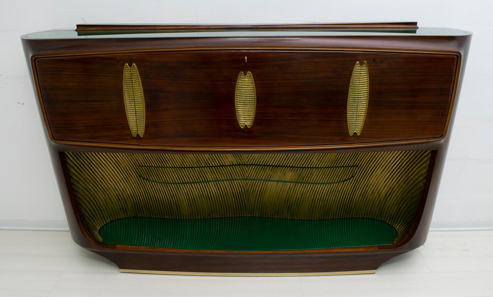 Ce meuble de bar a été conçu par le célèbre designer italien Vittorio Dassi, Italie 1950, le meuble est en noyer et les dessus en verre vert, la partie interne en dessous est en bois sculpté et doré avec des nuances de vert, la base a une finition