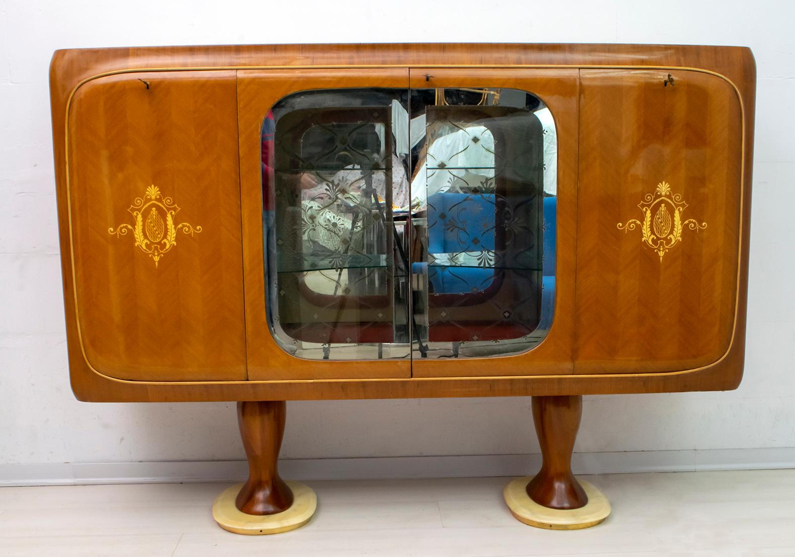 This bar cabinet was designed by the famous Italian design Vittorio Dassi, Italy, 1950. The cabinet is covered in herringbone mahogany with maple inlays and glass top, the central internal part is in mirrored glass with decorations, the central